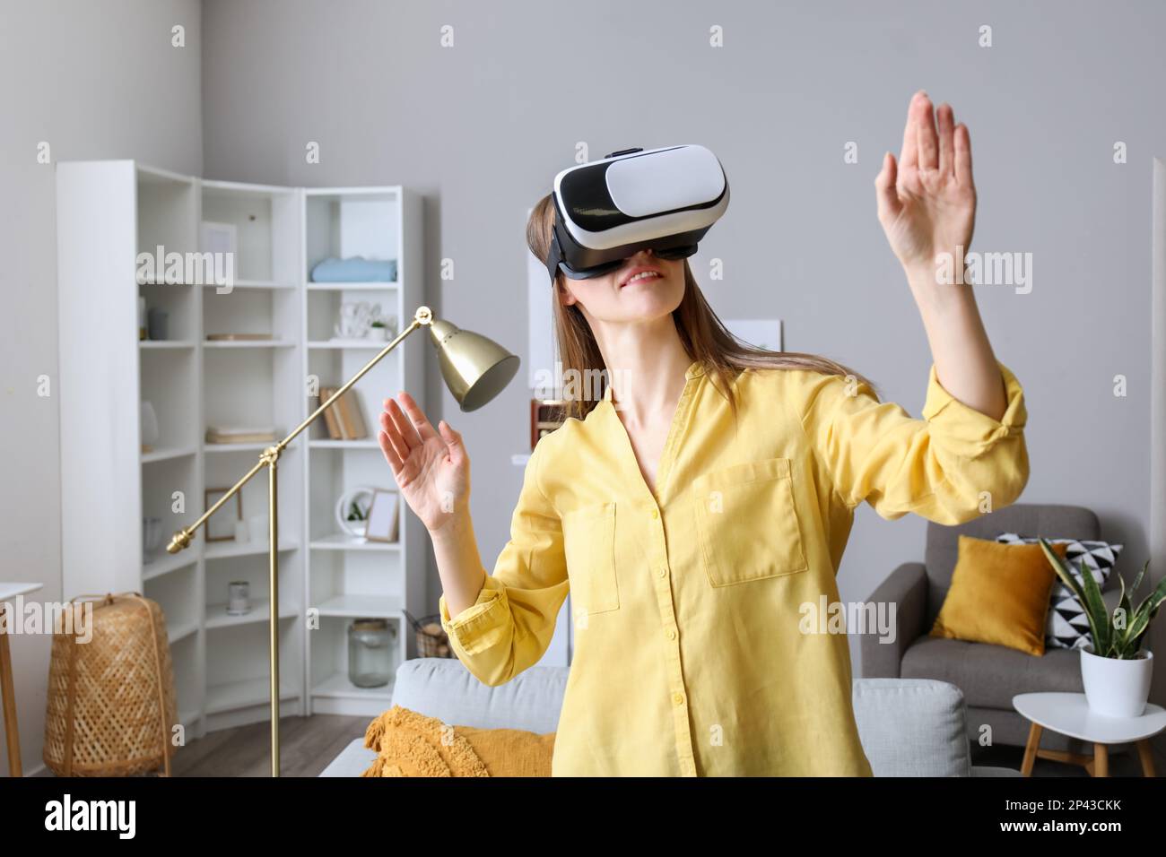 Pretty young woman in VR glasses at home Stock Photo - Alamy