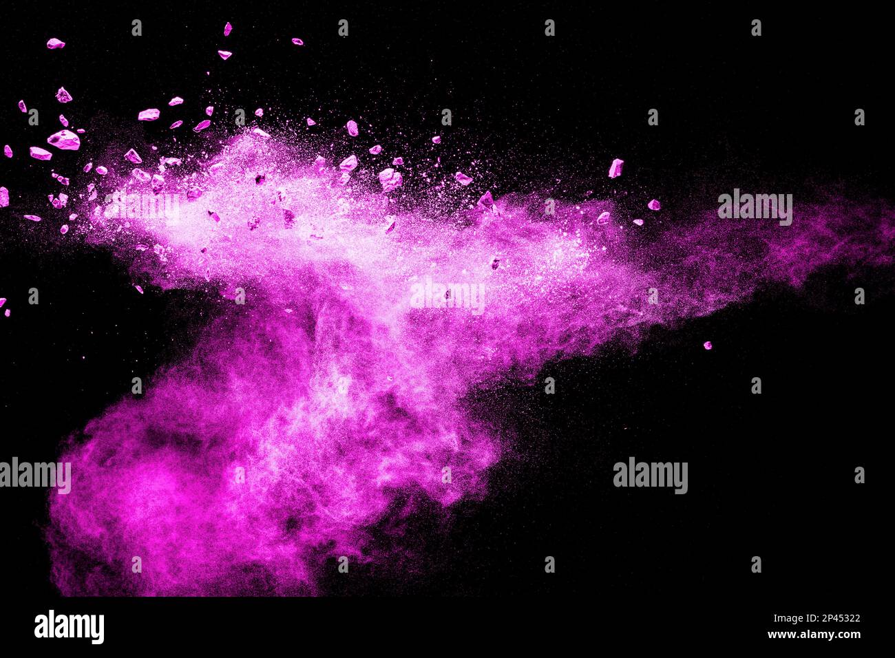 Split debris of stone exploding with pink dust powder against black background. Stock Photo