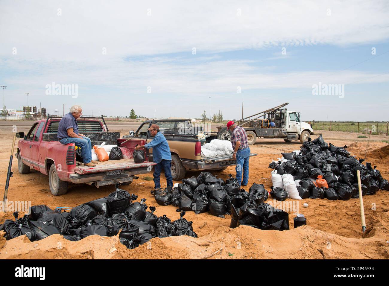 Pecos, Texas, residents load pickup trucks with sandbags Tuesday, Sept
