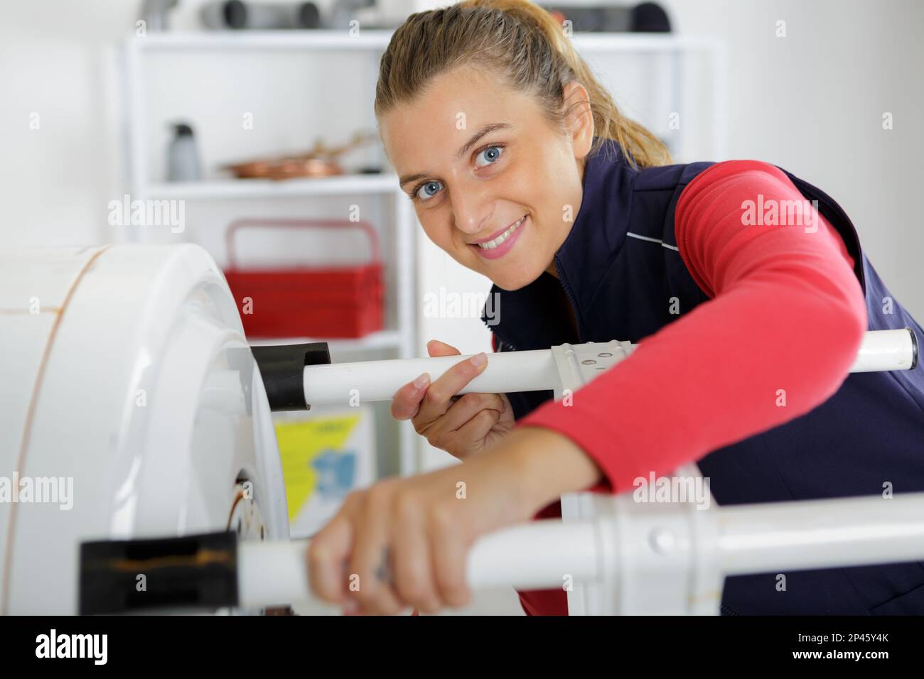 female technician servicing a boiler using tablet computer Stock Photo
