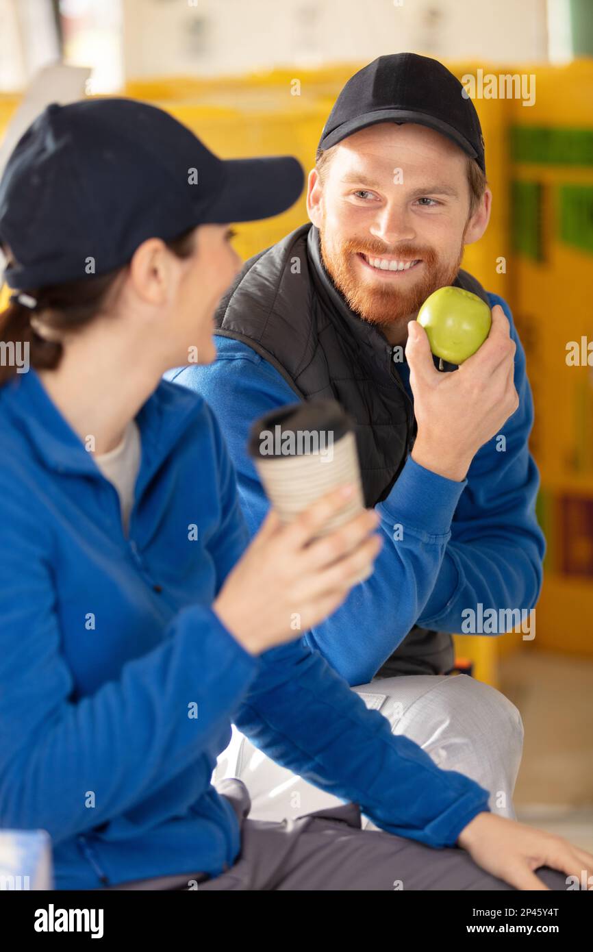 construction workers having a break and eating apple Stock Photo