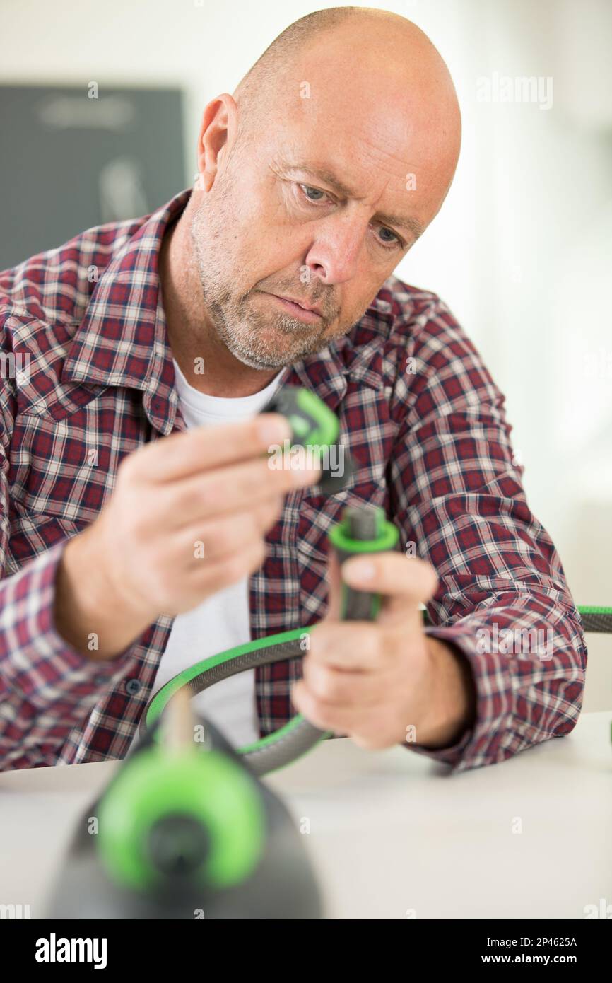 man assembling pipe in bathroom Stock Photo