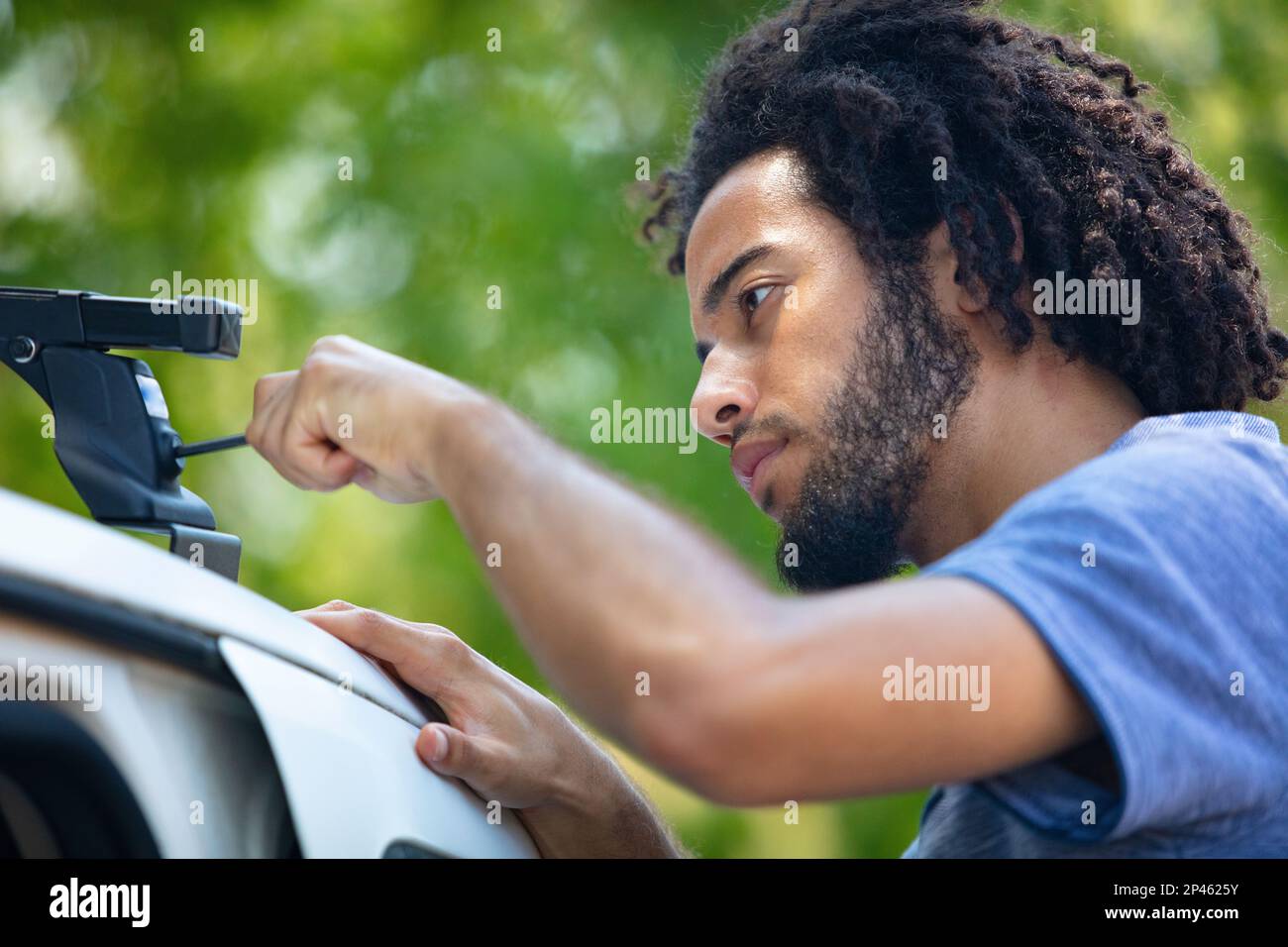 man fixing a car roof rack outdoors Stock Photo Alamy