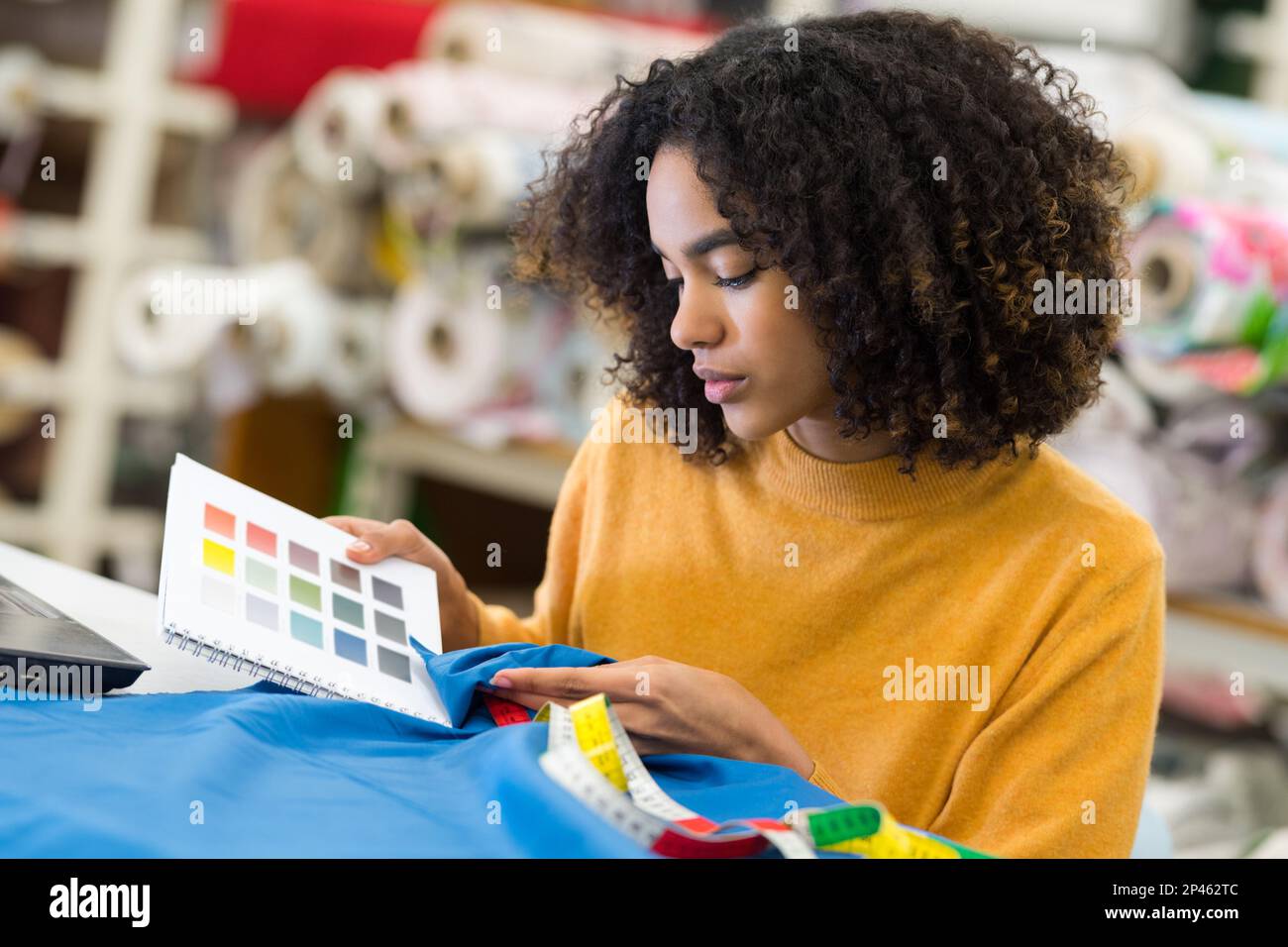 woman comparing fabric color to color preferred by her client Stock Photo