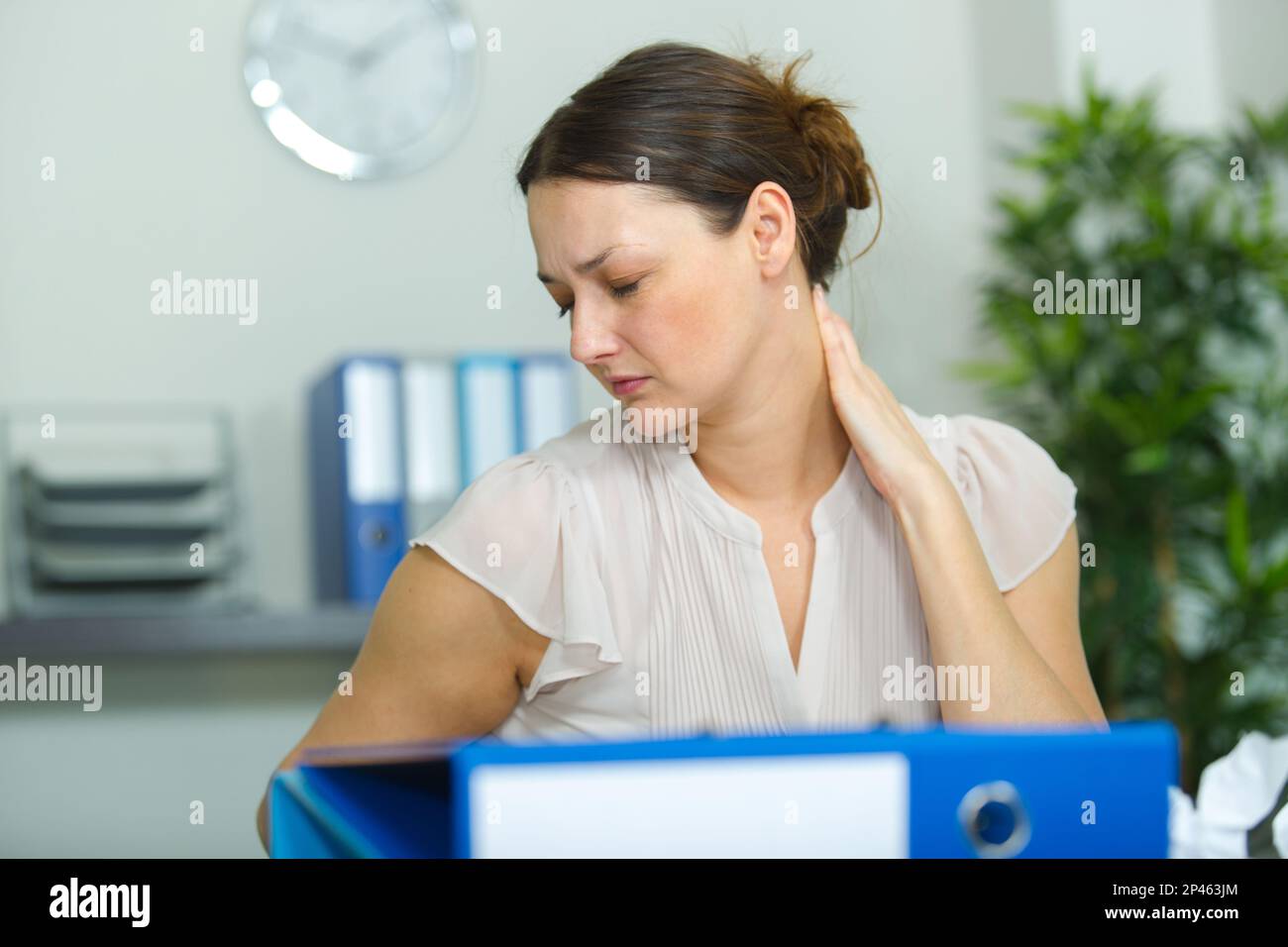 female office worker rubbing her aching neck Stock Photo - Alamy
