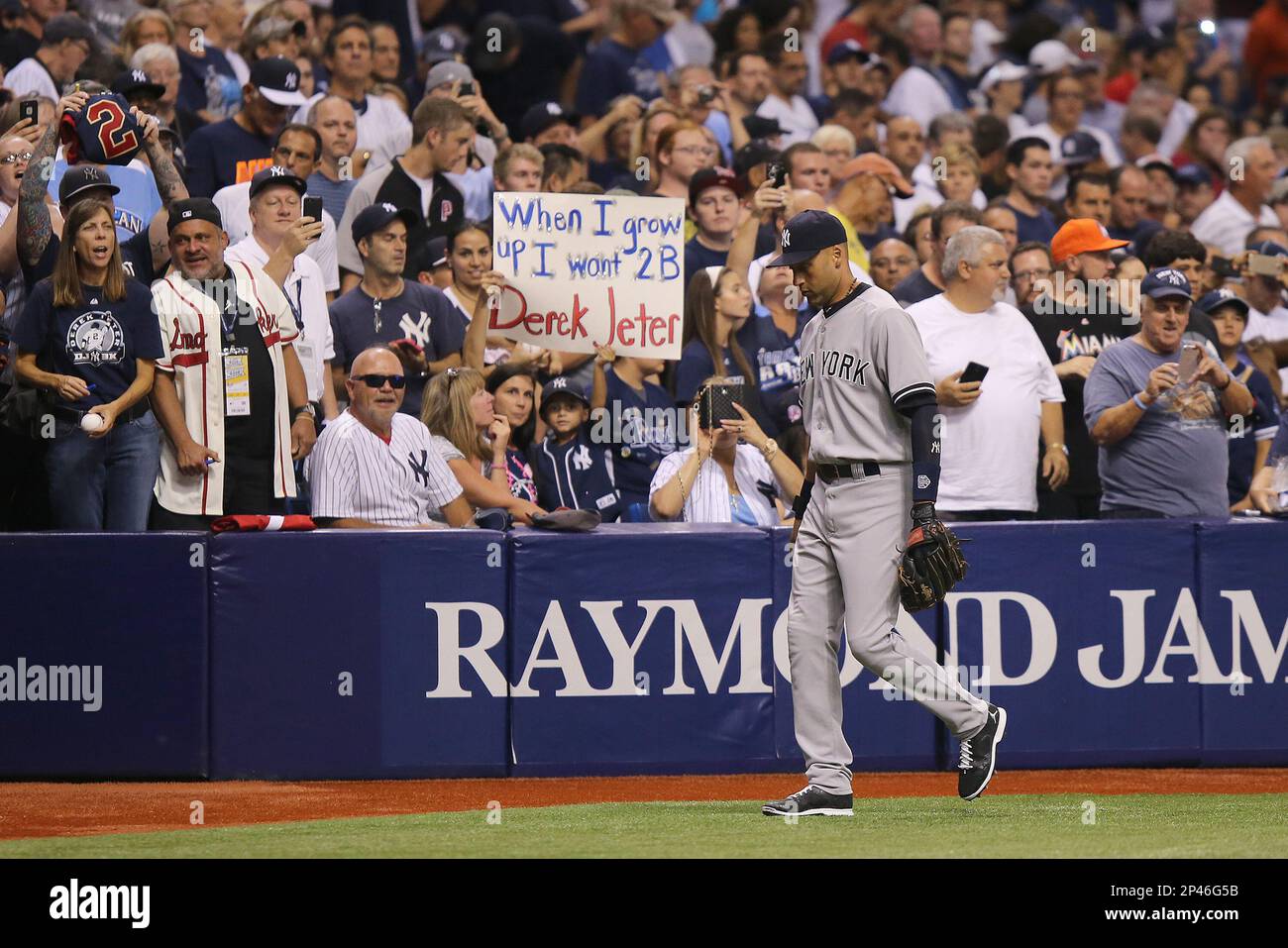 New York Yankees shortstop Derek Jeter (2) hands a ball to a young fan  between innings during a major league baseball game between the New York  Yankees and the Tampa Bay Rays