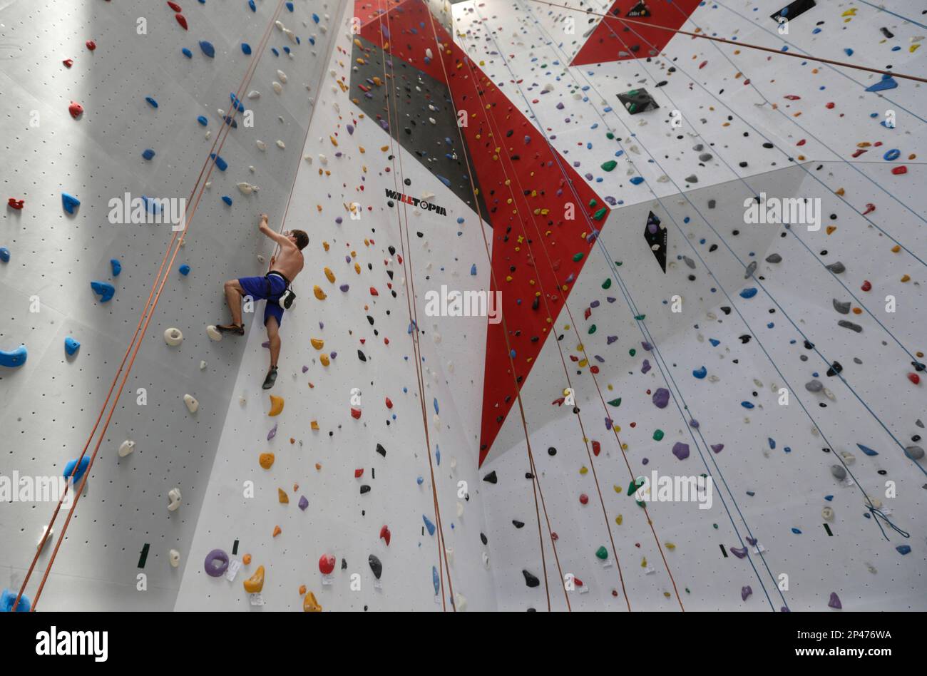 A man climbes a vertical wall at the 'Bleau' indoor climbing gym, in