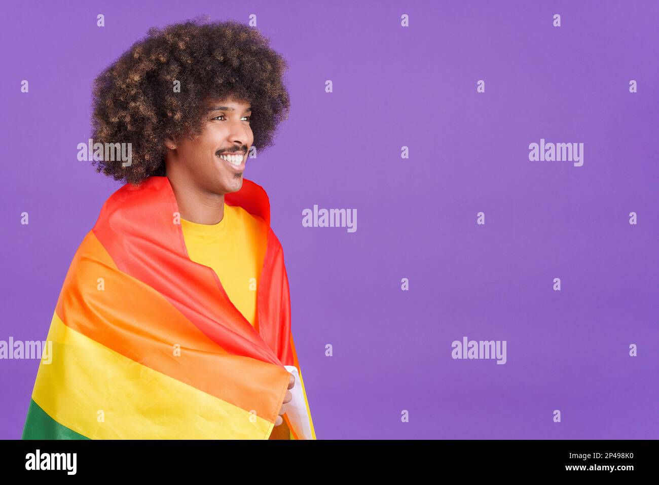 Smiling african man wrapped with a lgbt flag Stock Photo - Alamy