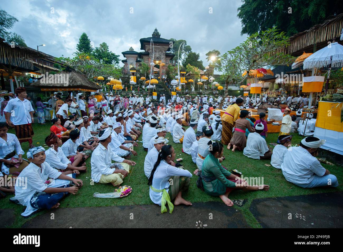 People sitting during Siat Sampian (coconut leaf war) festival, Pura Samuan Tiga, Ubud, Bali, Indonesia Stock Photo