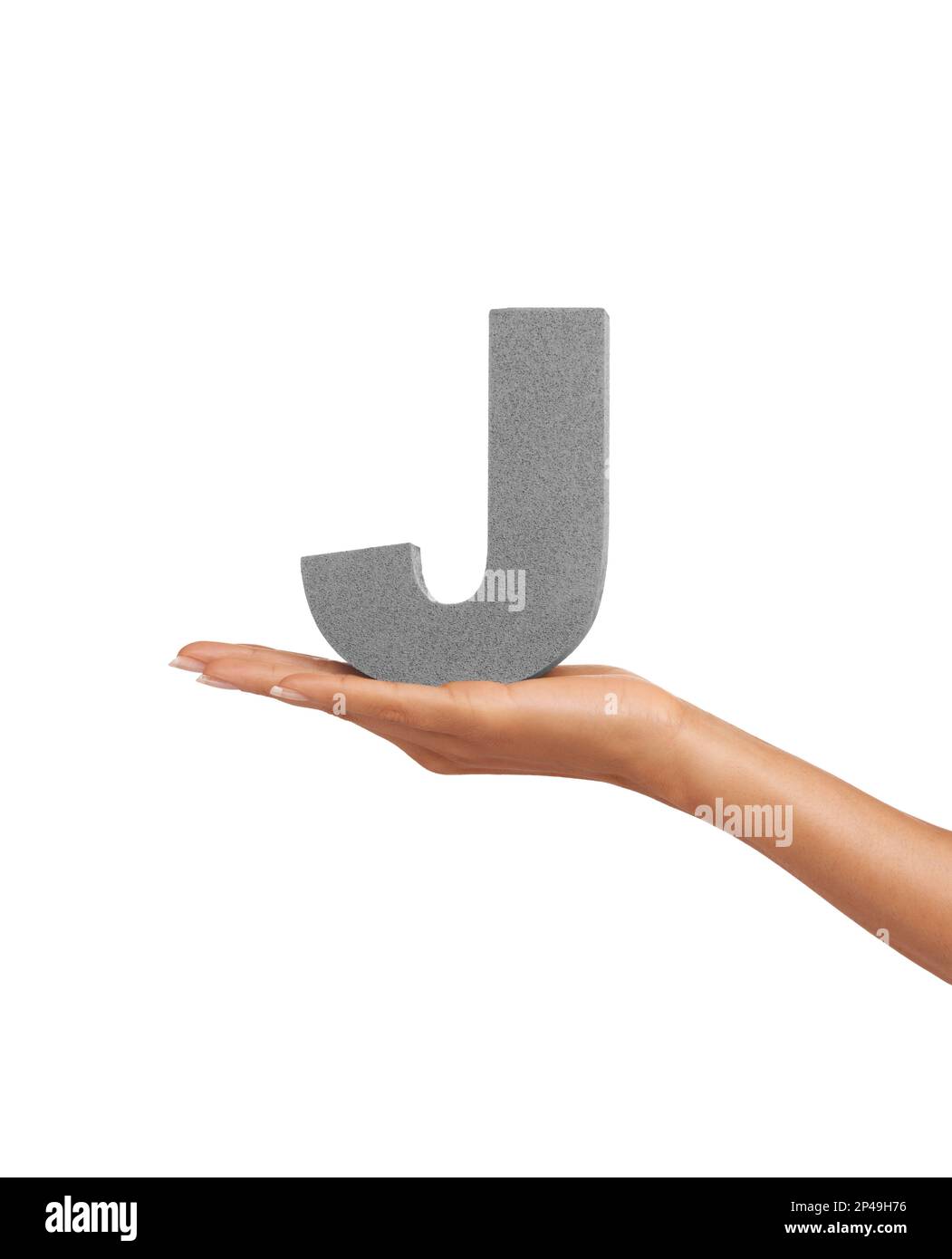 Here is a J. A young woman holding a capital letter J isolated on a white background. Stock Photo