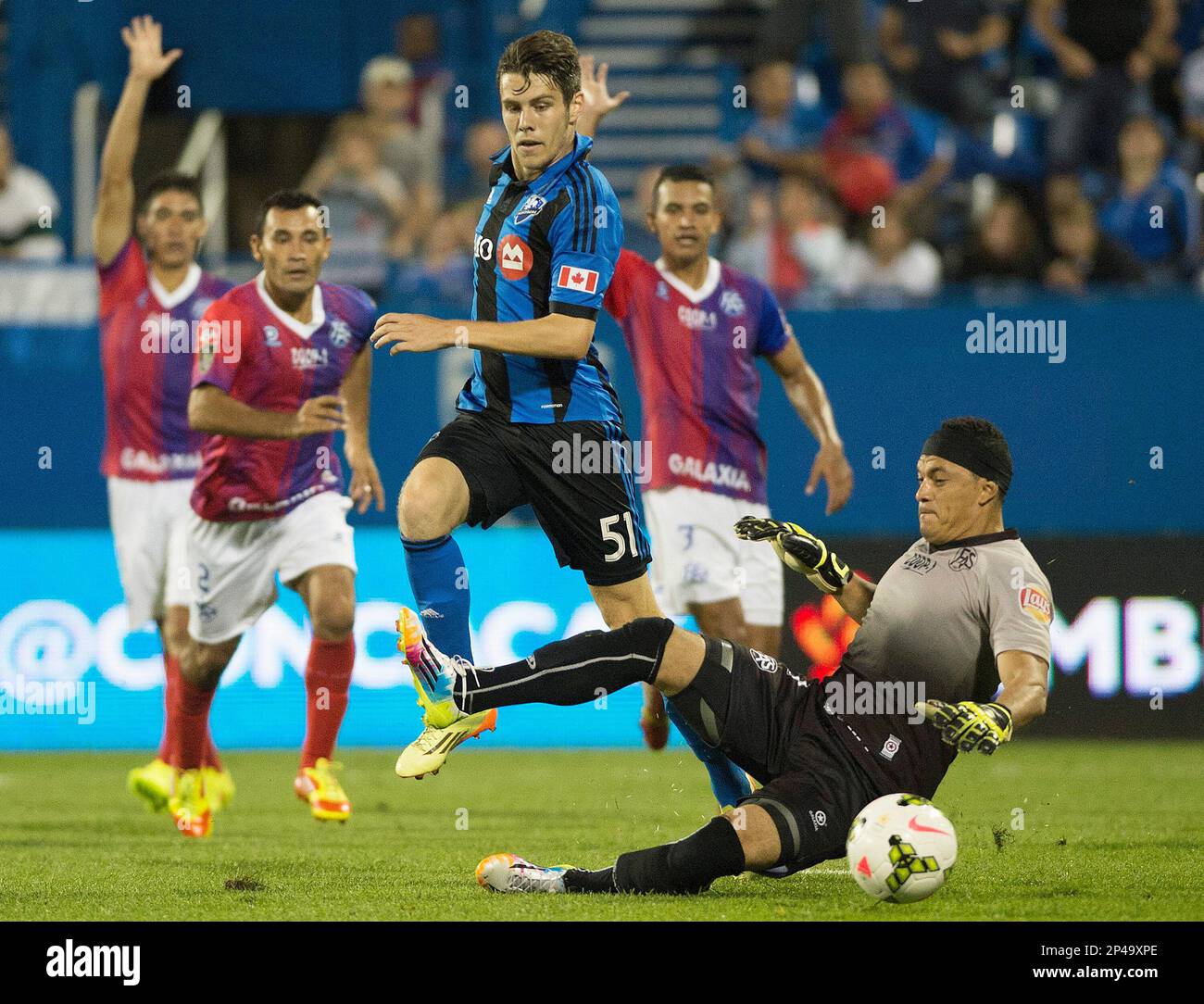 FAS goalkeeper Luis Contreras slides in on Montreal Impact s Maxim