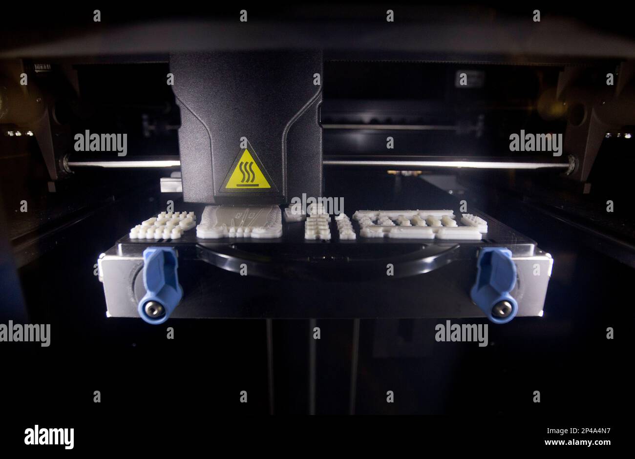 In this July 17, 2014 photo, a 3D printer works on parts for a
