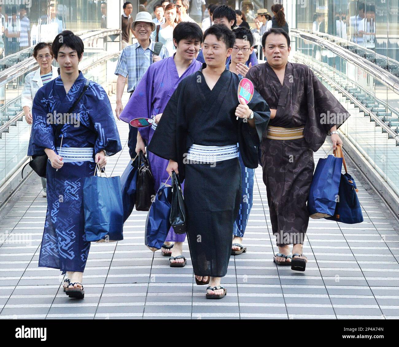 Men wearing yukata head to work in Shibuya Ward, Tokyo on July 30, 2014. As  part of a  Shibuya Summer Festival event to promote traditional Japanese  culture among young people and