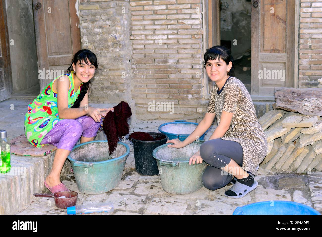 Uzbek women working in a small rug family owned factory in the old city of Bukhara, Uzbekistan. Stock Photo