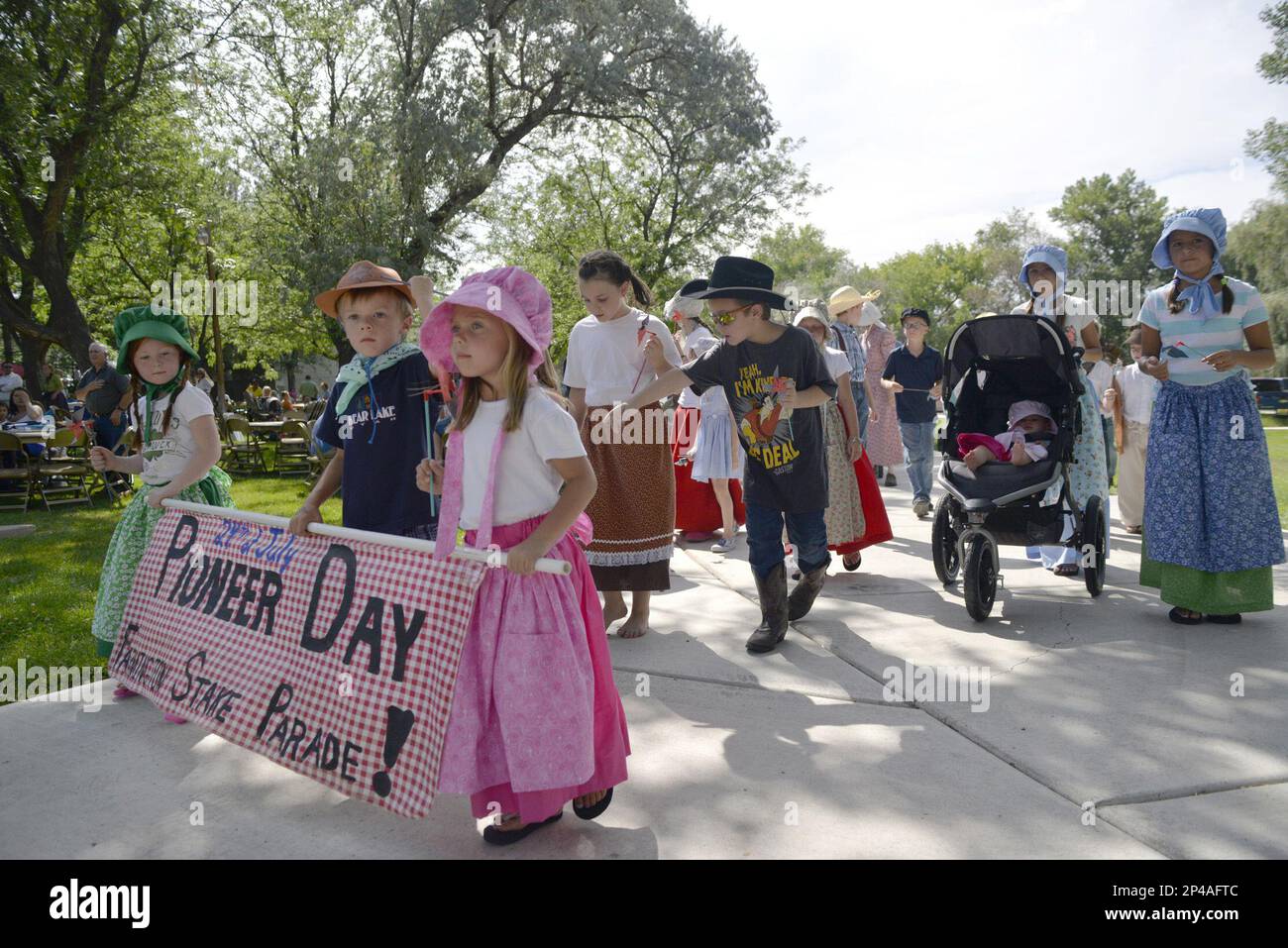 Parade participants walk through the park during the Pioneer Day Celebration at Taylor Park in