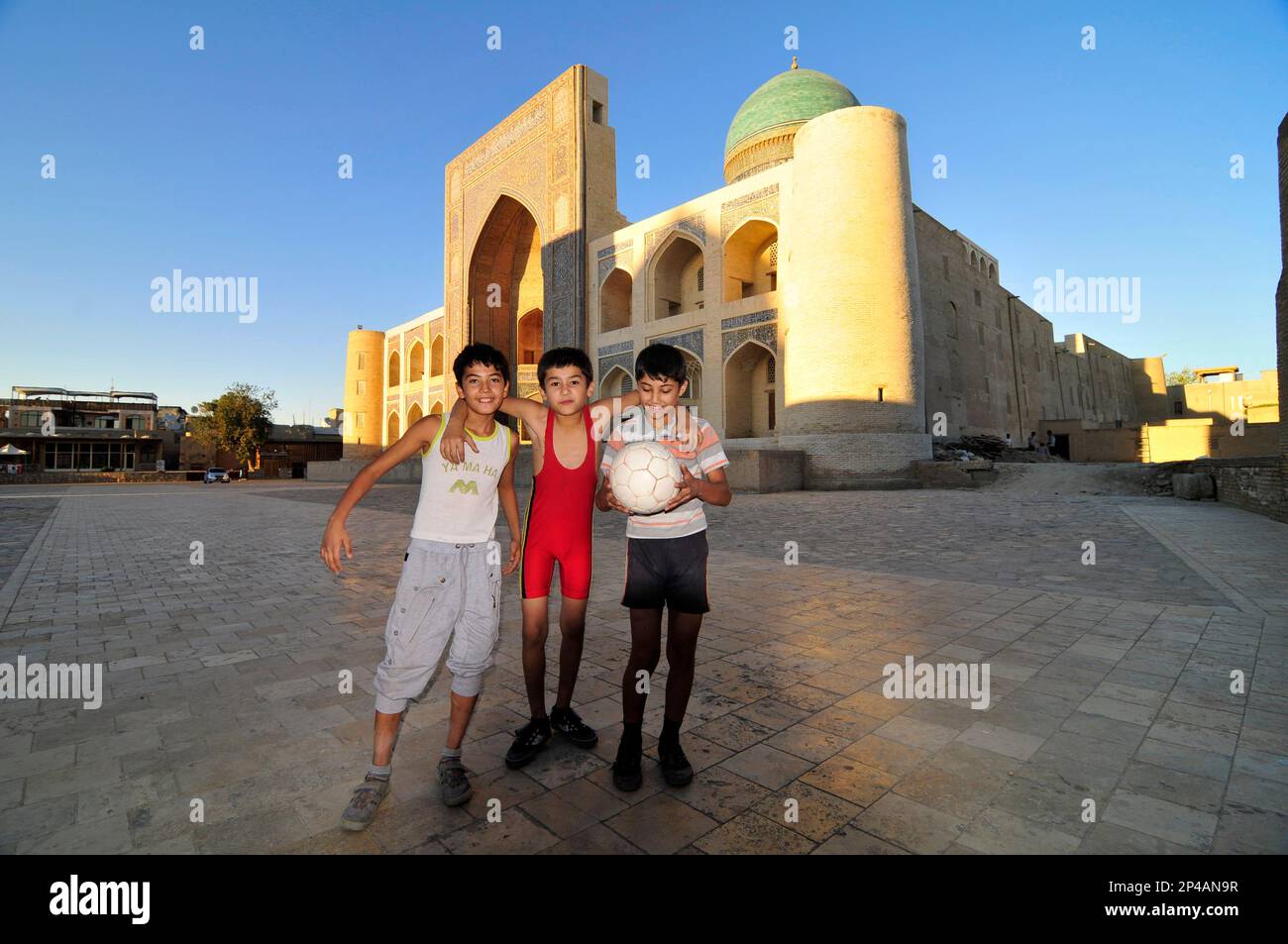 Uzbek boys playing football by the Kalan mosque in the old city of ...