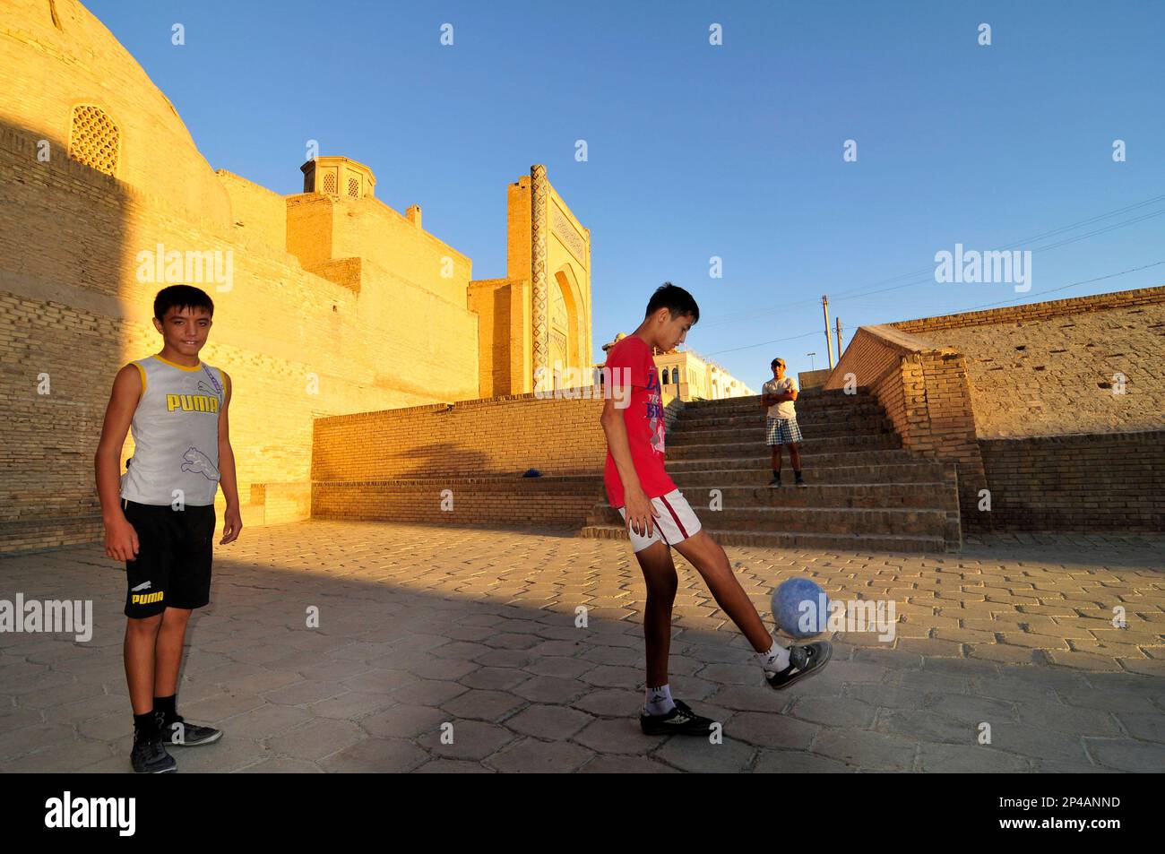Uzbek boys playing football by the Kalan mosque in the old city of ...