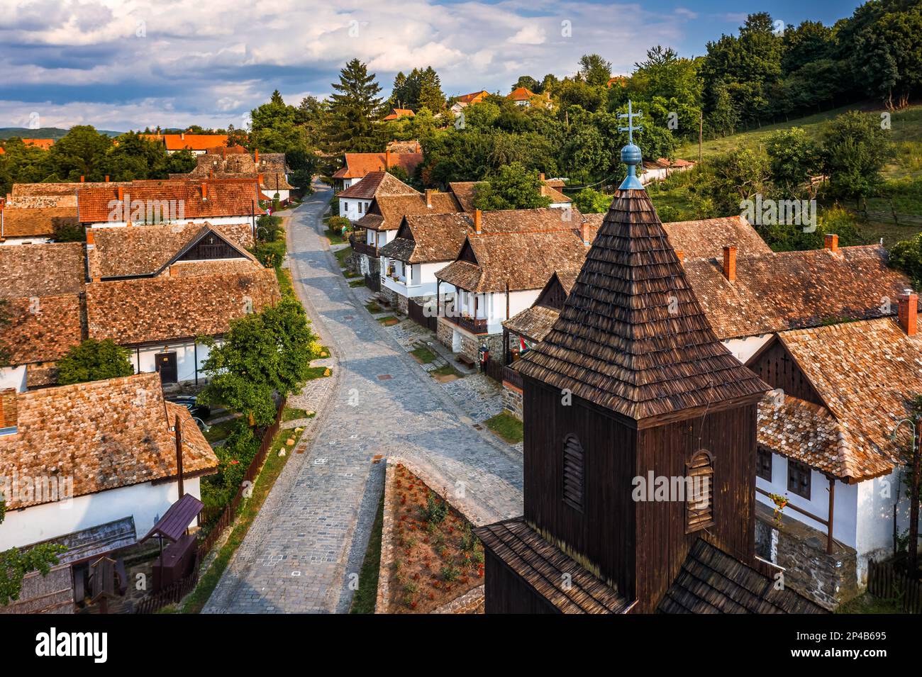 Holloko, Hungary - Aerial view of the tower of the traditional catholic church of Holloko at the village centre, an UNESCO site in Hungary on a sunny Stock Photo