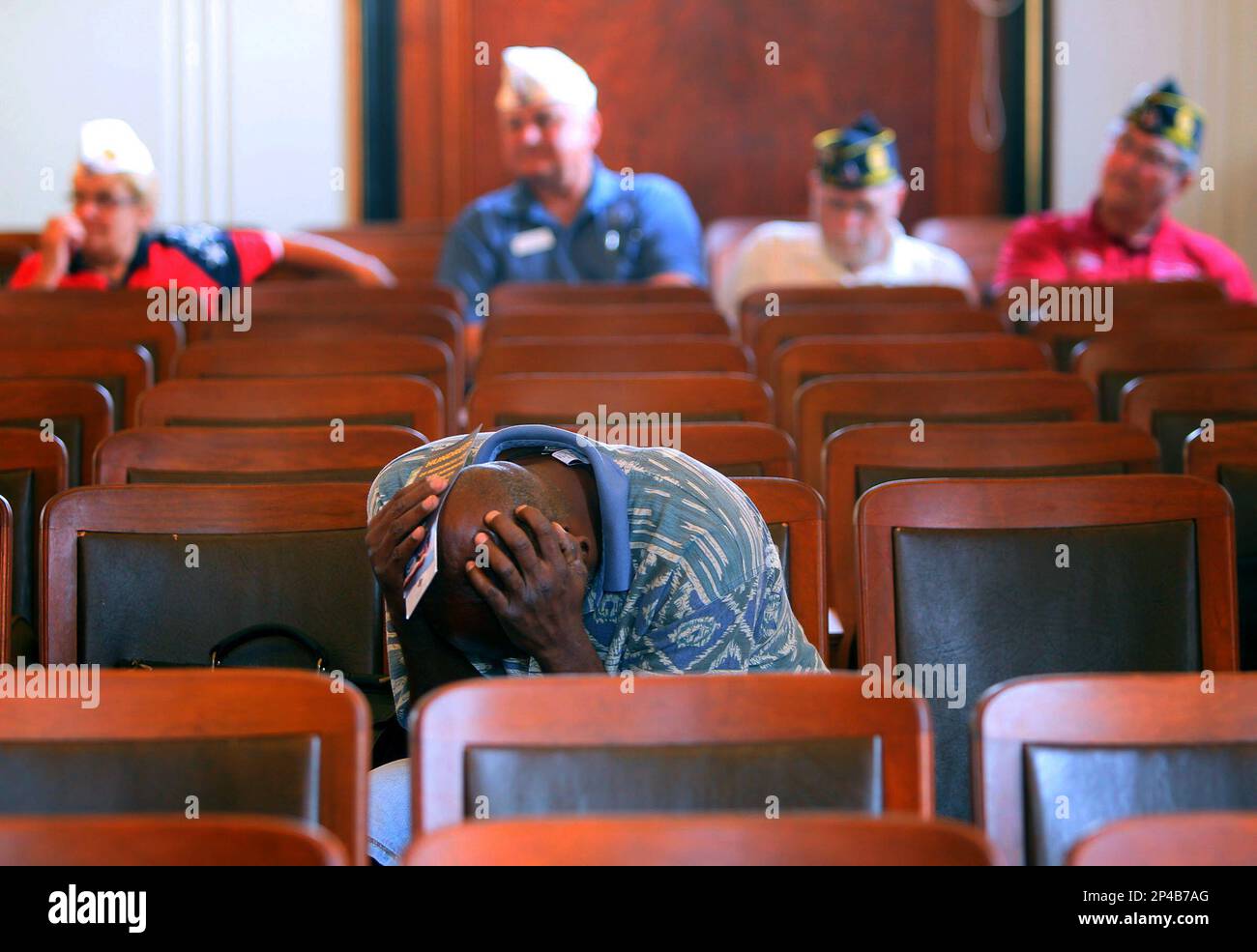 Veteran Clarence Graham holds his head in his hands after he spoke
