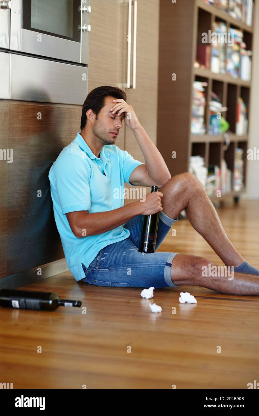 Drowning his sorrows. a crying man drinking wine while sitting on the