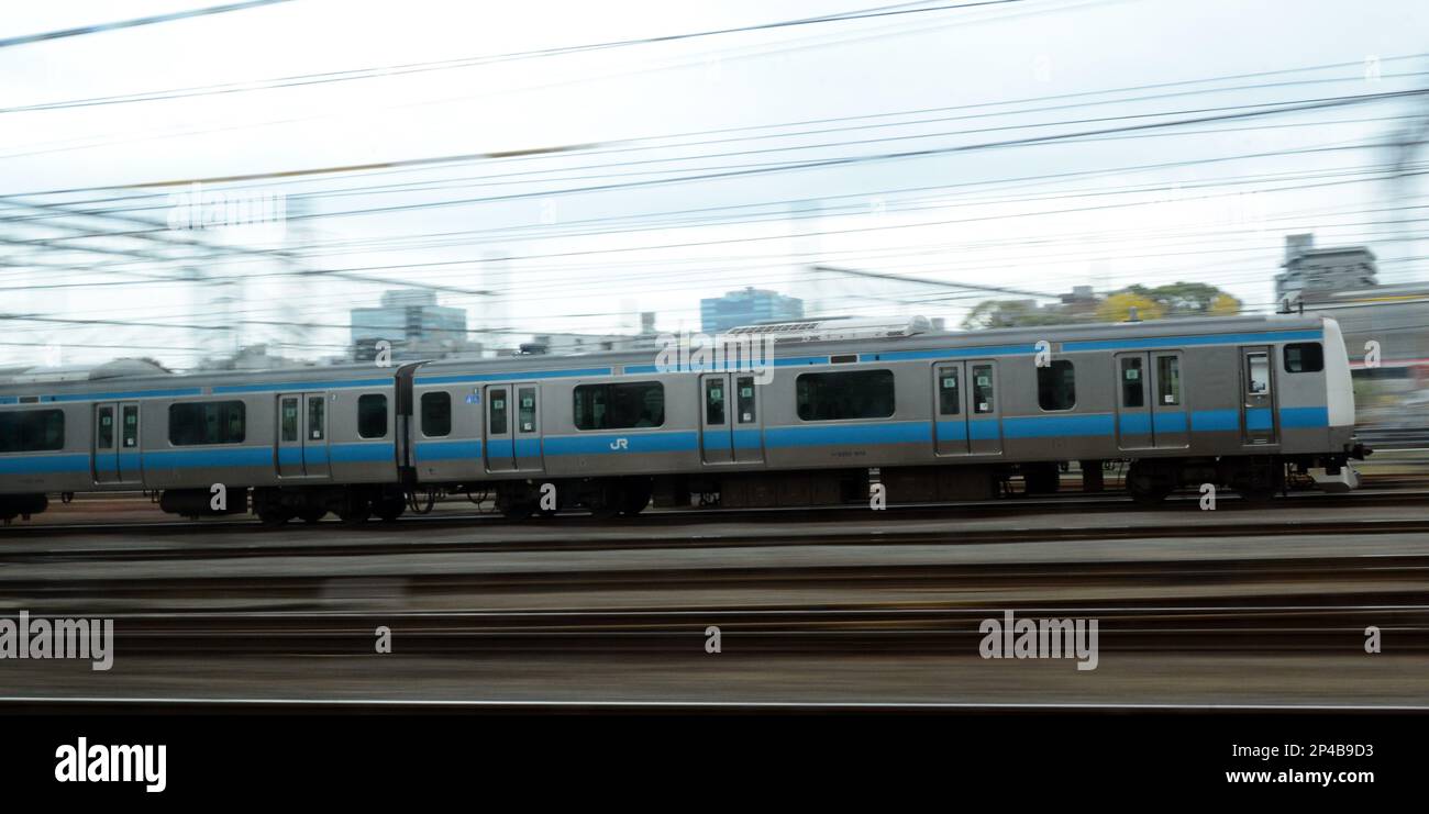 A JR local train in motion in the suburbs of Tokyo, Japan. Stock Photo