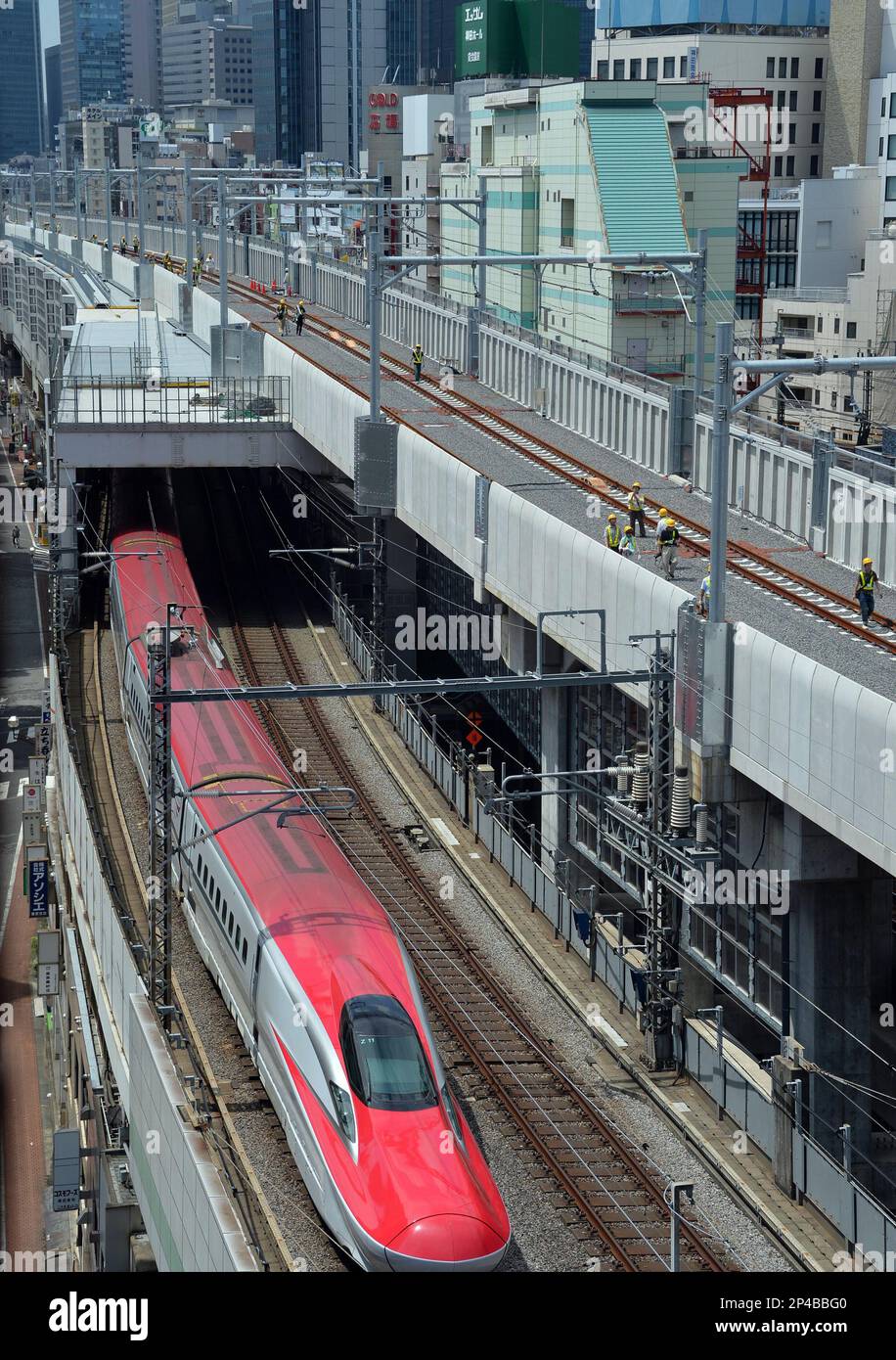 People in Tokyo walk on newly built tracks (R, above) between 