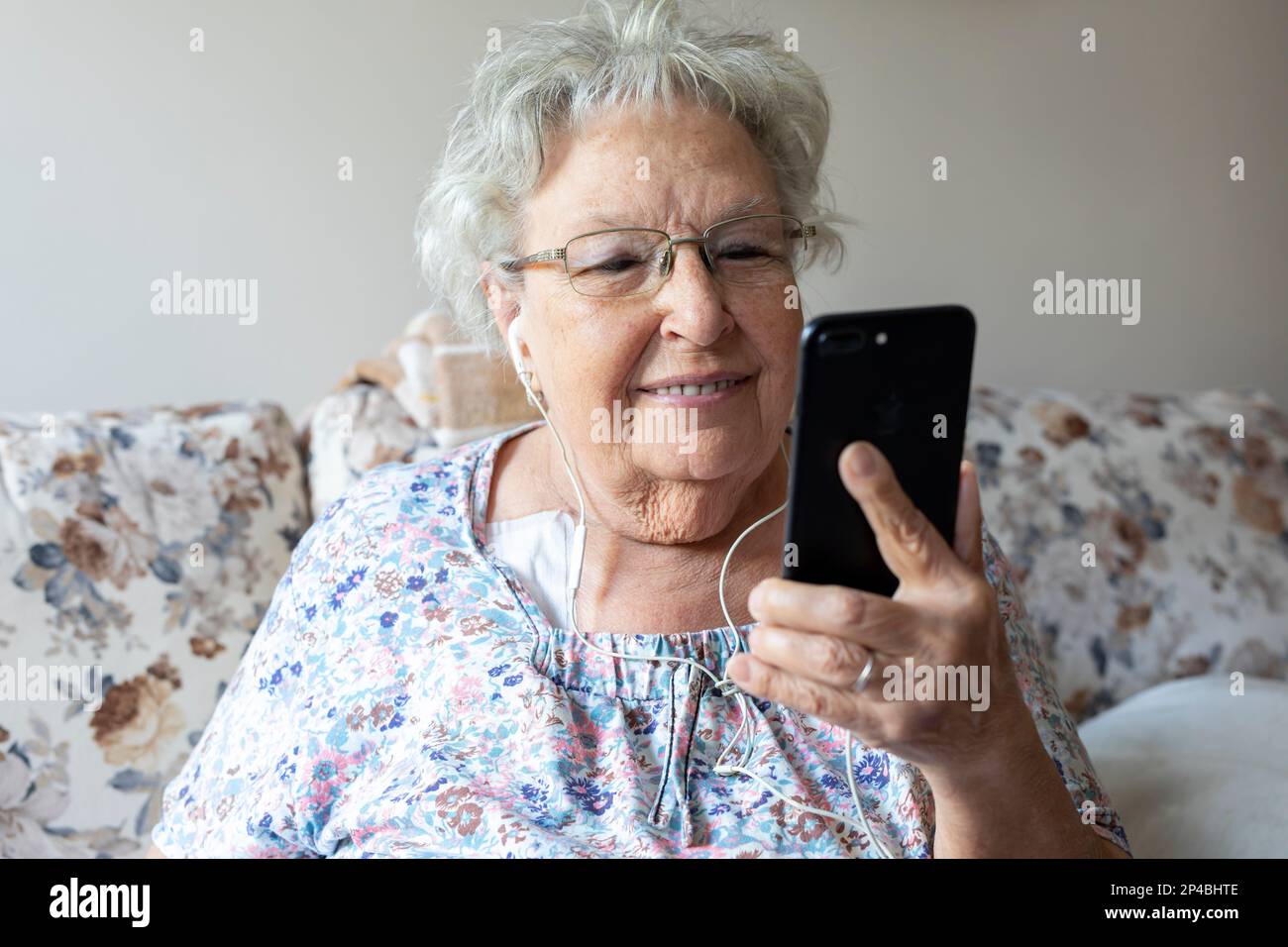 Elderly woman talks on a mobile phone home Stock Photo