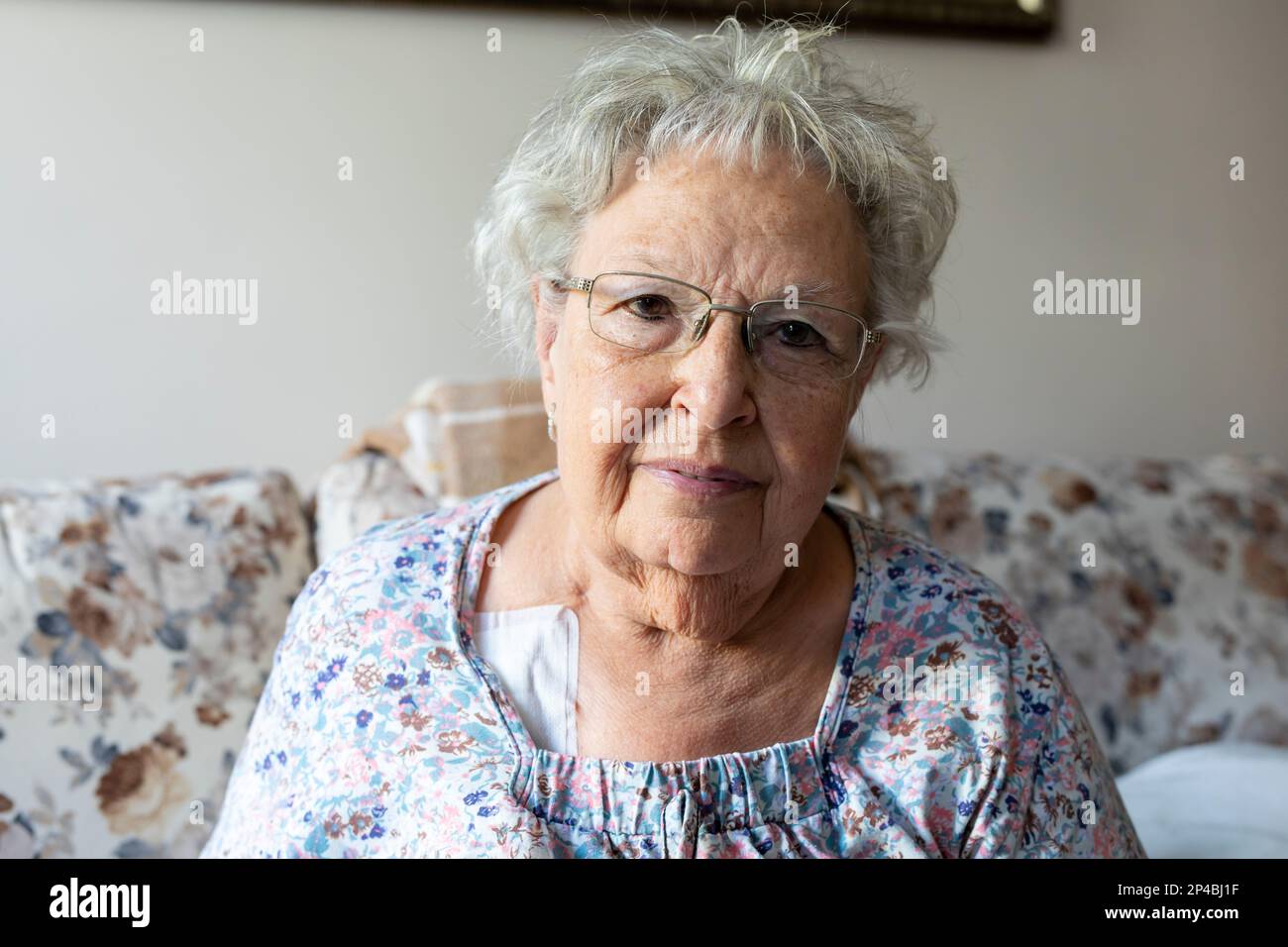 Portrait of a beautiful old woman with gray hair and glasses Stock Photo