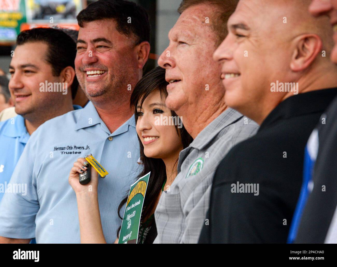 Ileana Quintanilla, center, poses for cameras with representatives of