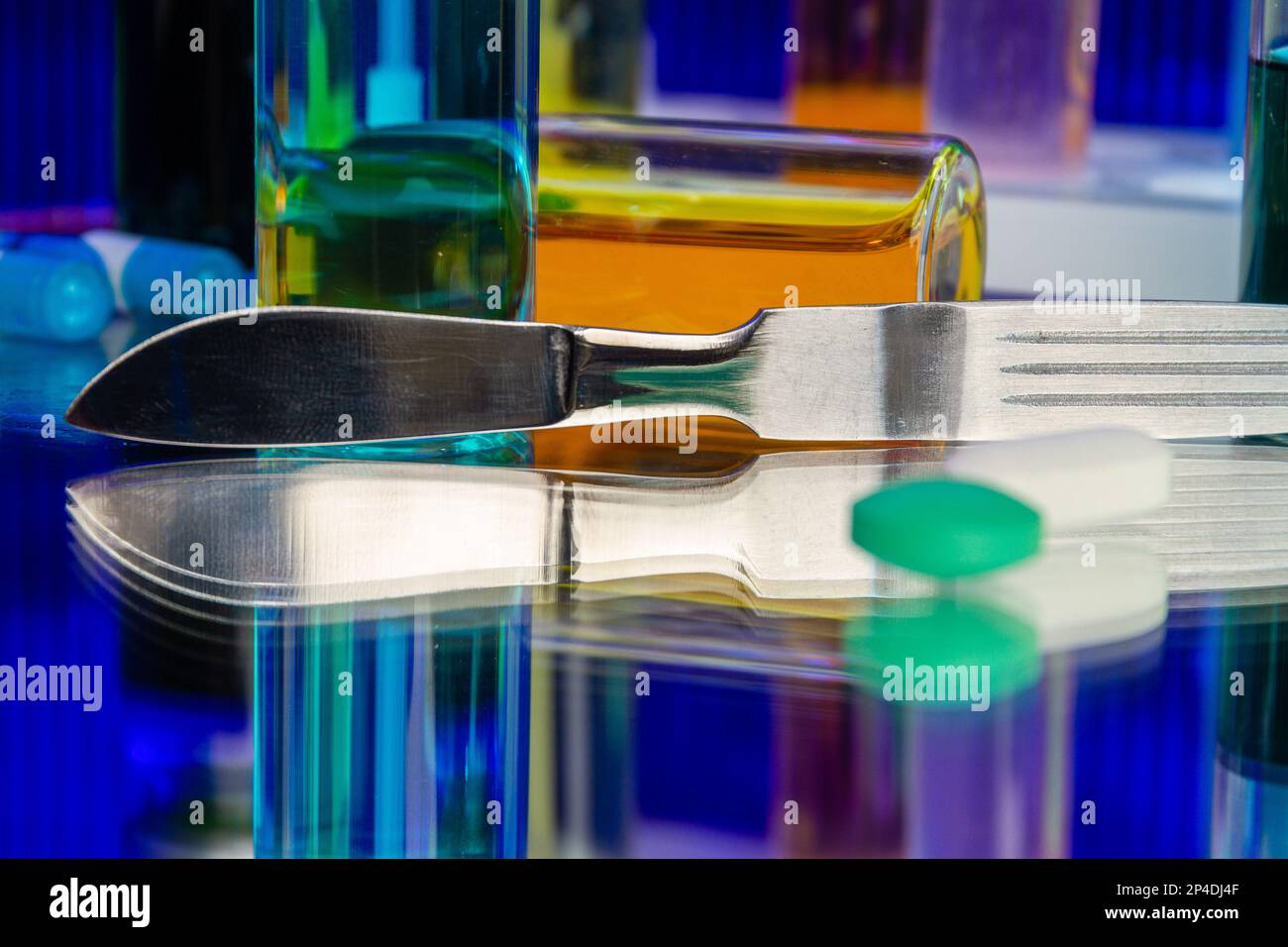 Metallic surgical knife and bottles of medicine. Science research