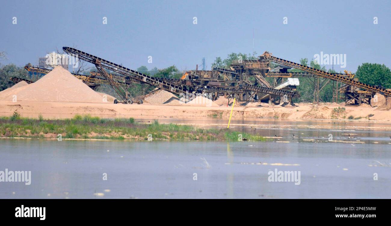 Floodwater surrounds the higher mounds of sand and equipment as the Poudre River continues to