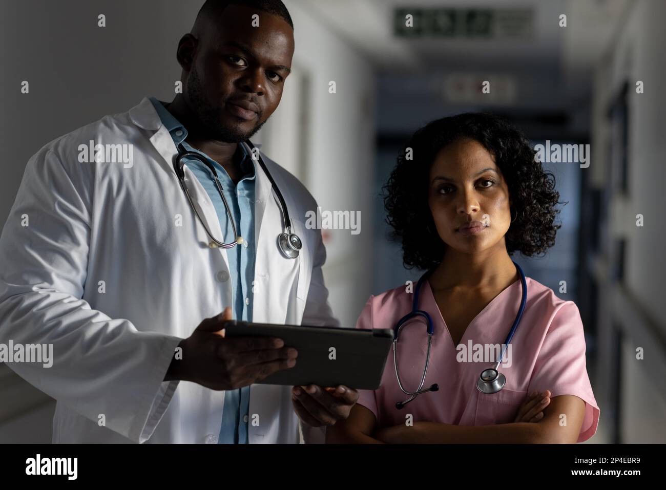 Portrait of diverse male and female doctors with stethoscopes and tablet in hospital Stock Photo