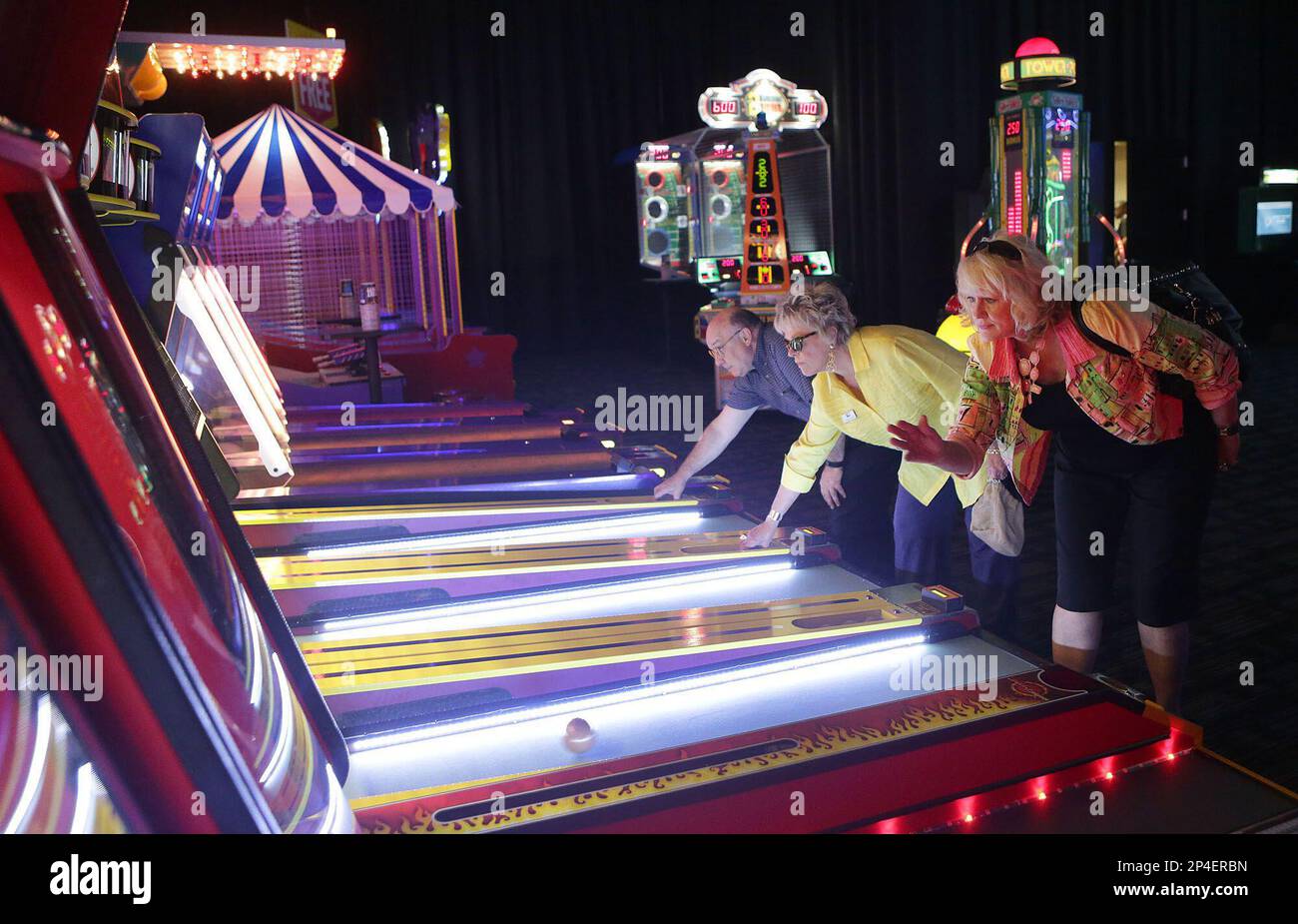 Bob Van Epps, from left, Denis Ramos and Genevieve Wright try their hand at skee ball during a