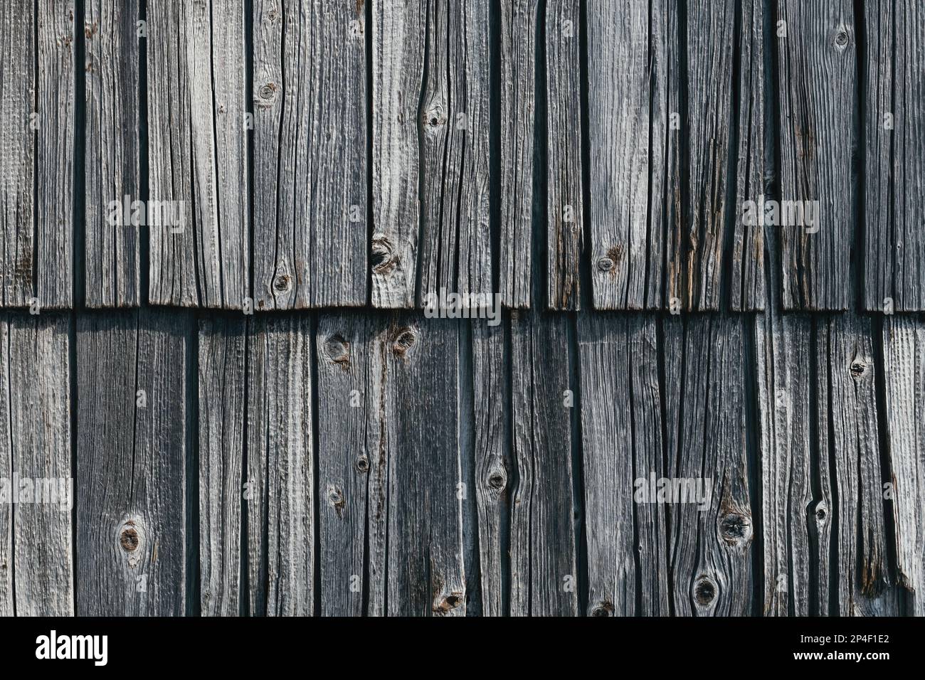 Worn wooden roof tile pattern, detail of a typical old slovenian alpine cottage roofing as background Stock Photo