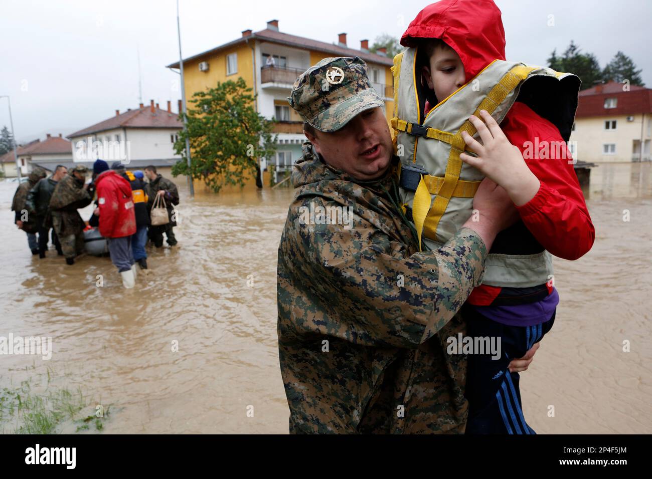 A member of the Bosnian army carries a boy rescued from his home ...