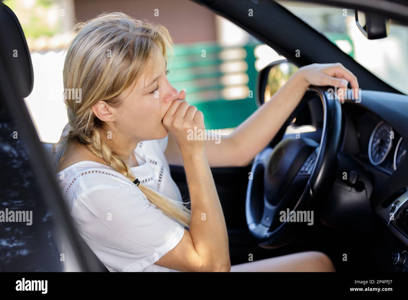 young tired woman in driver seat Stock Photo