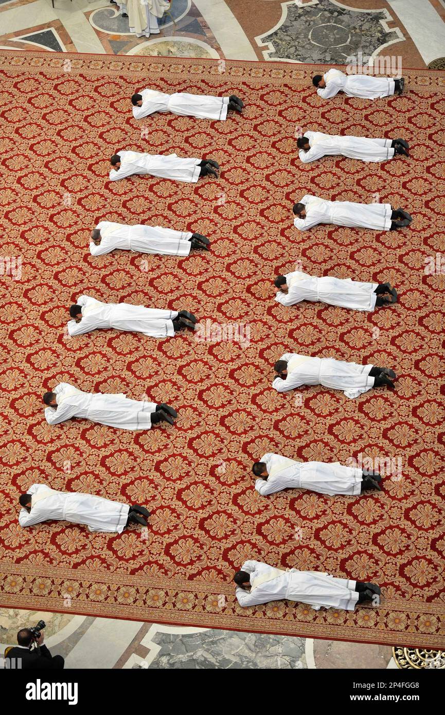 Thirteen new priests lay on the ground during a ceremony in which Pope Francis ordained them, in