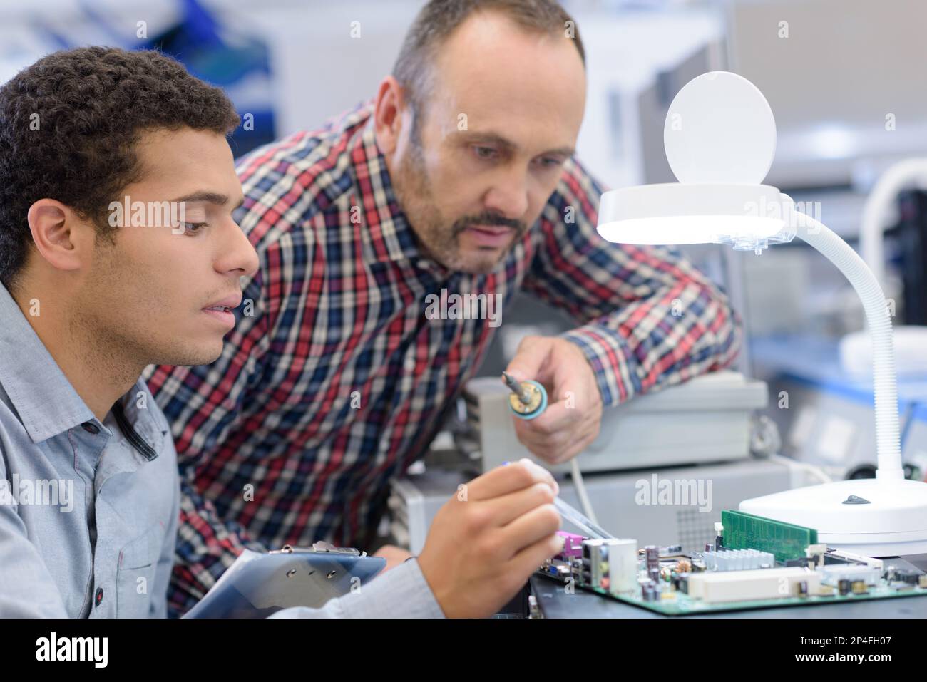 man soldering small chip parts Stock Photo Alamy