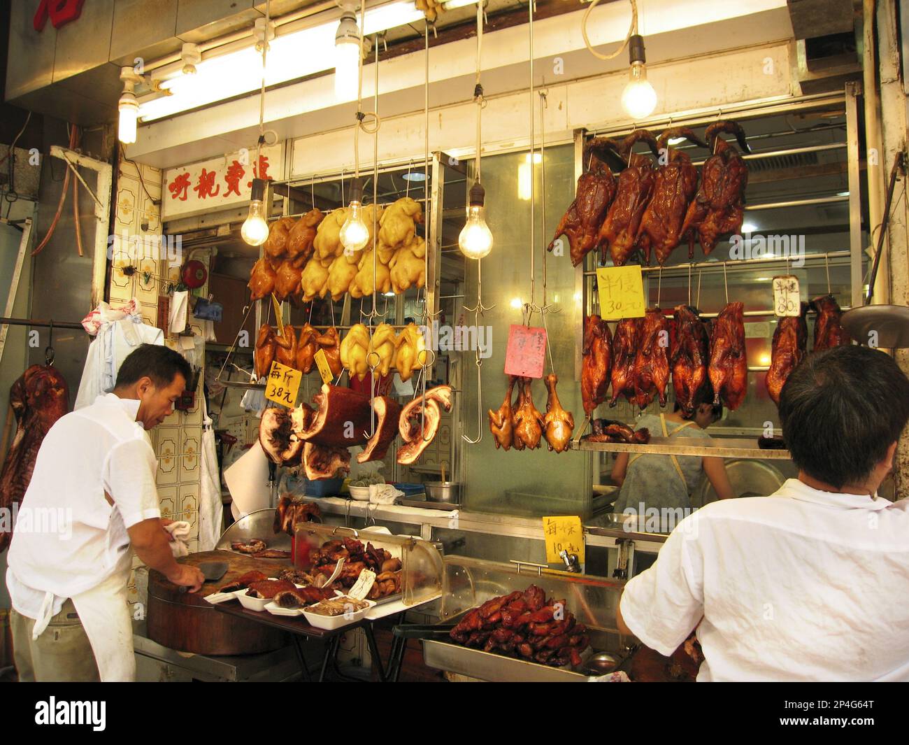 Man prepares meat and poultry in cafe, Kowloon, Hong Kong, China Stock Photo