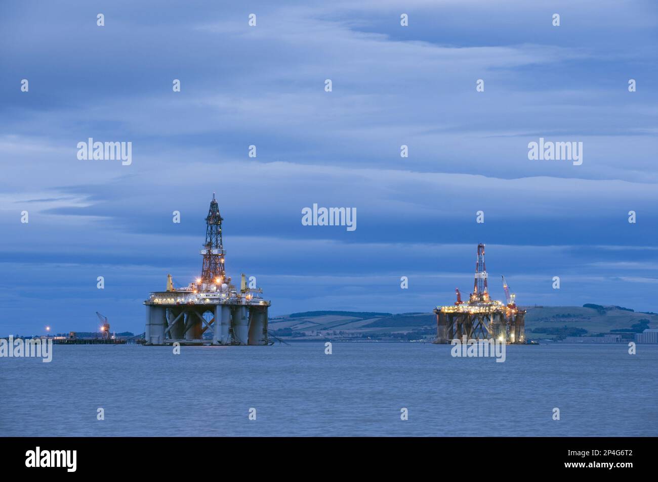 Oil rigs moored in sea near coast at dusk, Cromarty Firth, Moray Firth, Invergordon, Easter Ross, Scotland, United Kingdom Stock Photo