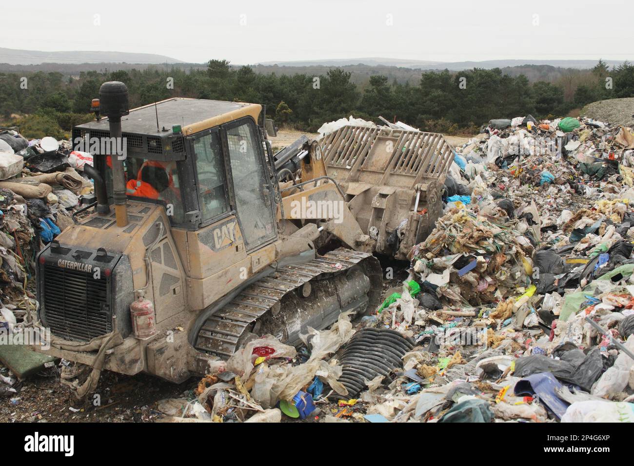 Bulldozer moving rubbish on landfill tip, Dorset, England, United Kingdom Stock Photo