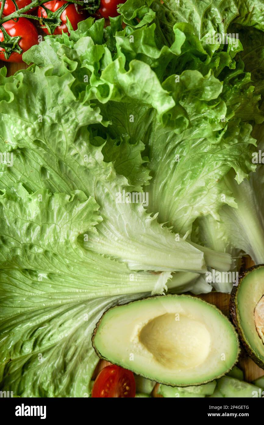Close up of salad ingredients: lettuce, avocado, tomatoes. Healthy food and dieting concept Stock Photo