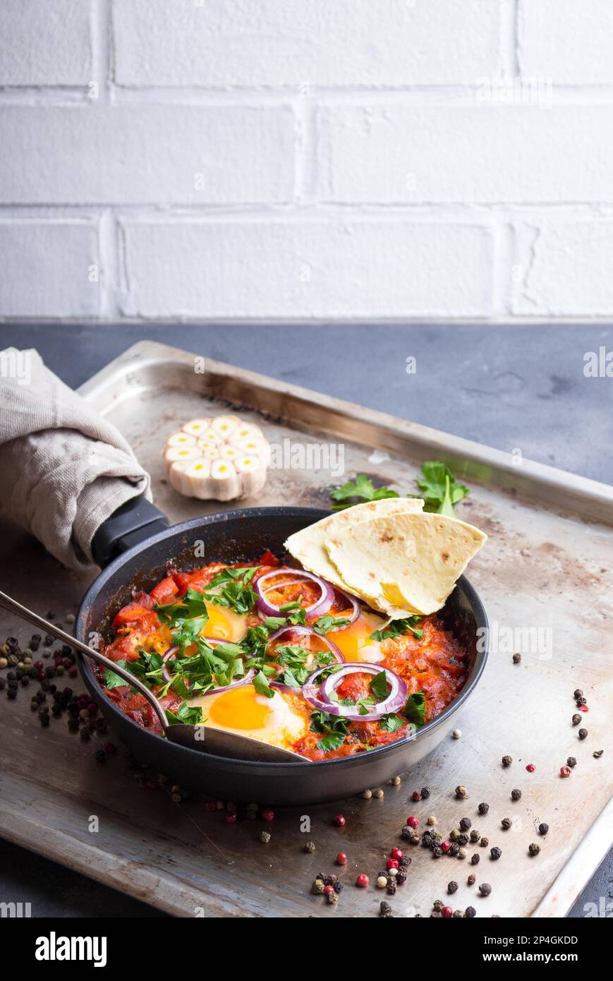 Shakshuka with pita bread in a pan. Middle eastern traditional dish ...