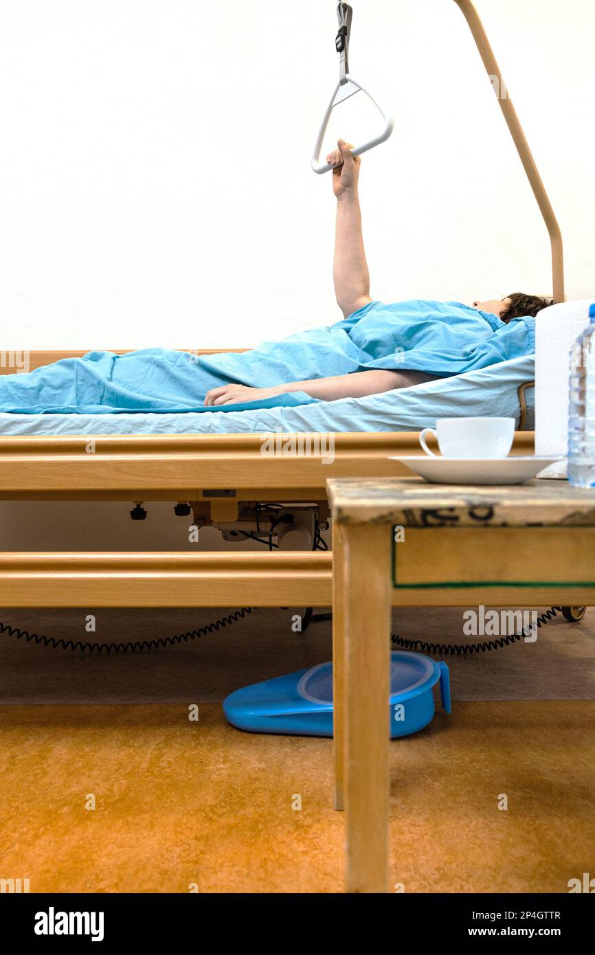 side view of homecare electric hospital bed with sick person holding