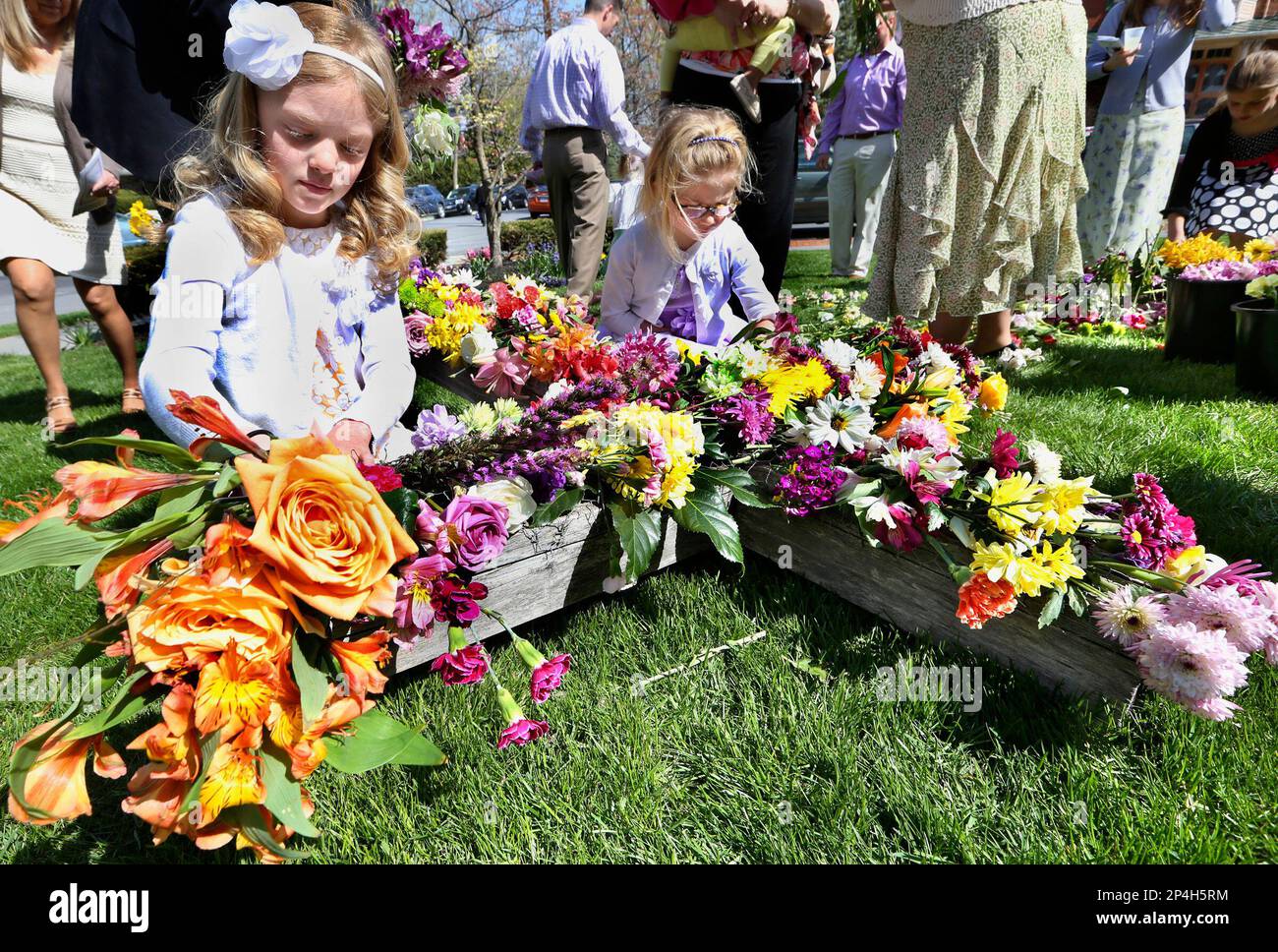 Lauren Masters 9, left and Carleigh Ritter 5 place flowers on the cross