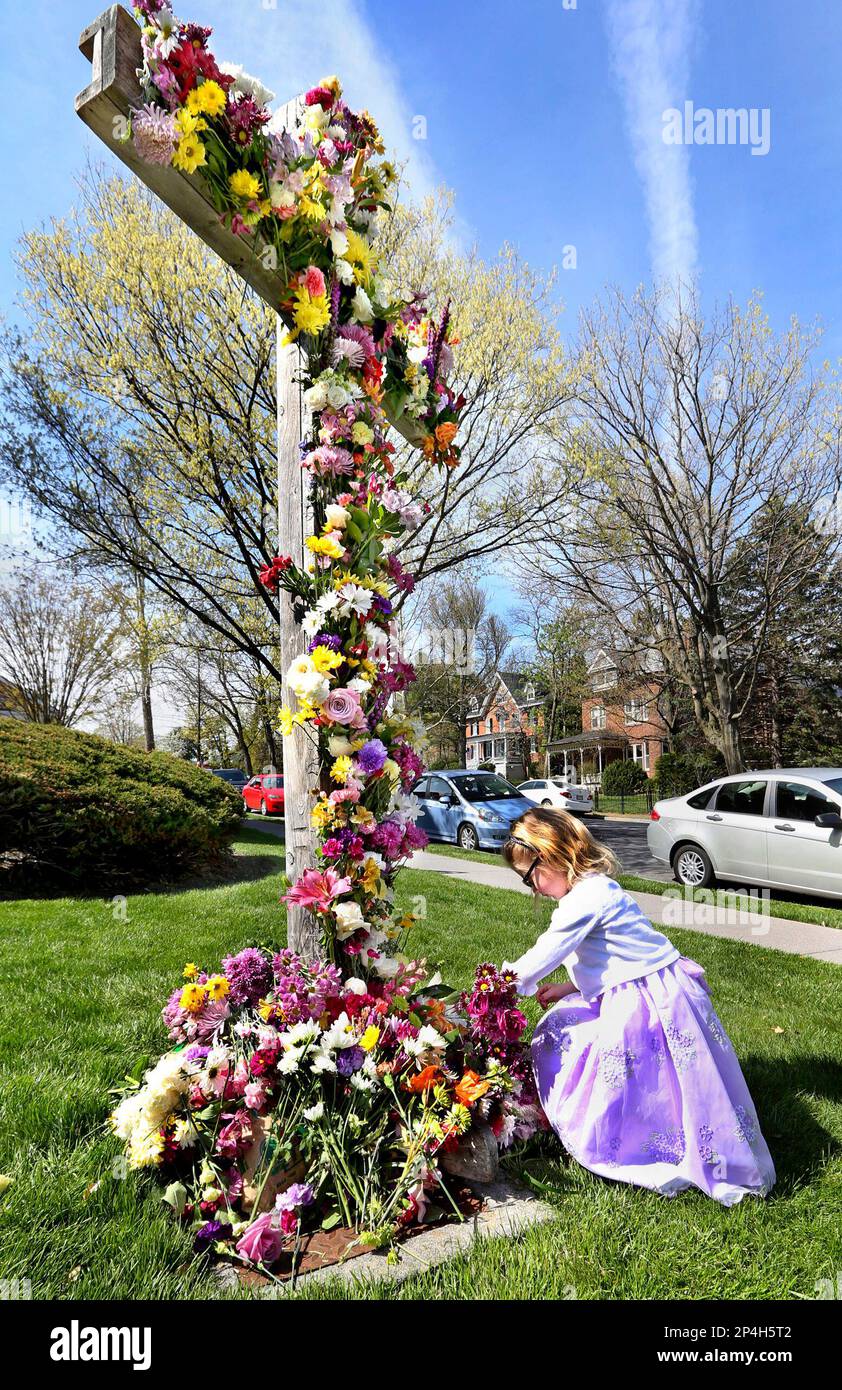 Carleigh Ritter 5 places flowers at the foot of the cross on the lawn