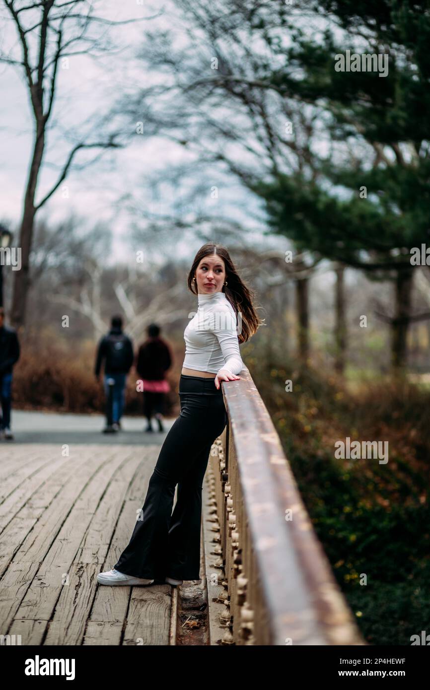 Teen girl standing on bridge looking over shoulder Stock Photo