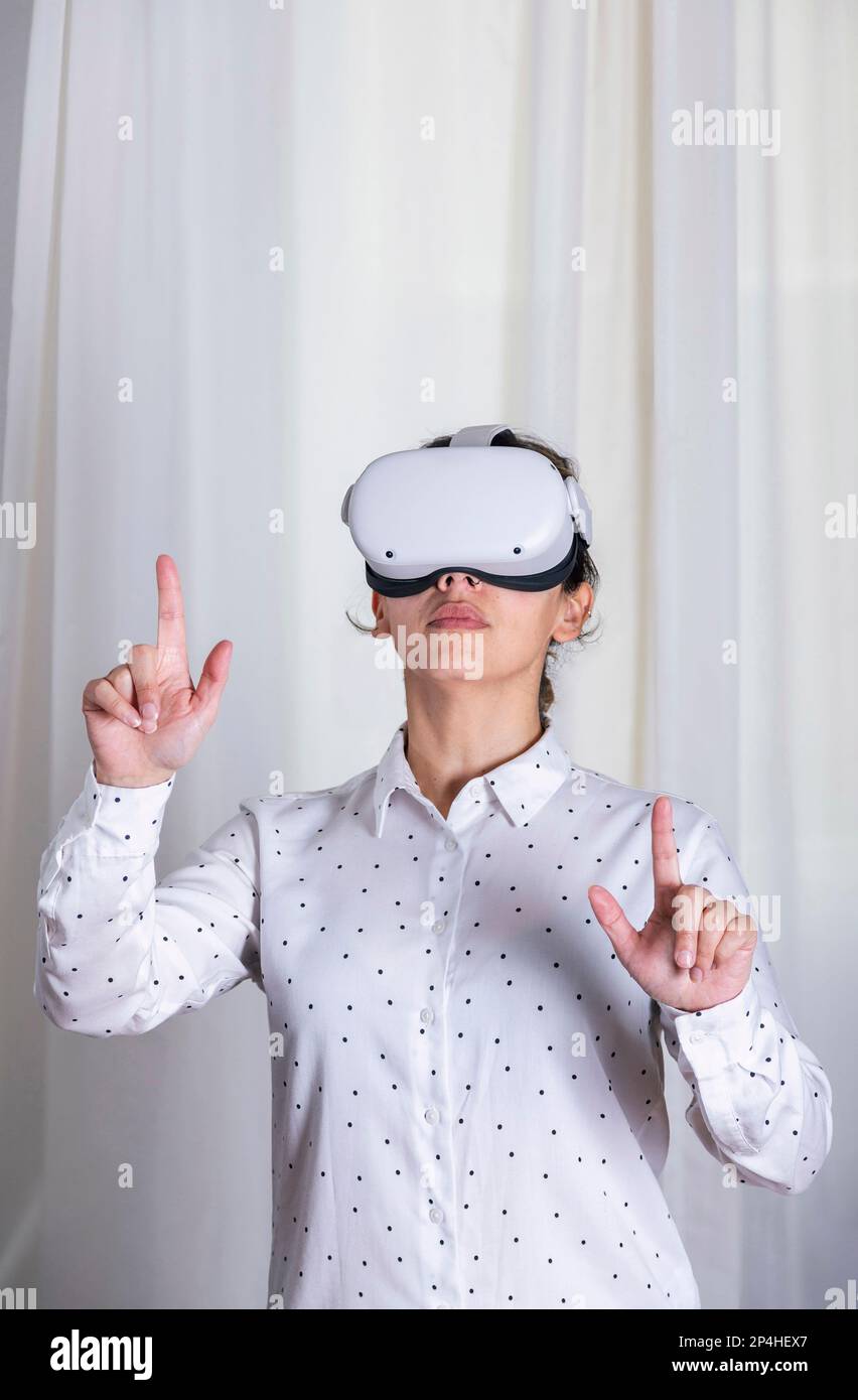 Young woman using vr glasses pointing at something. Stock Photo