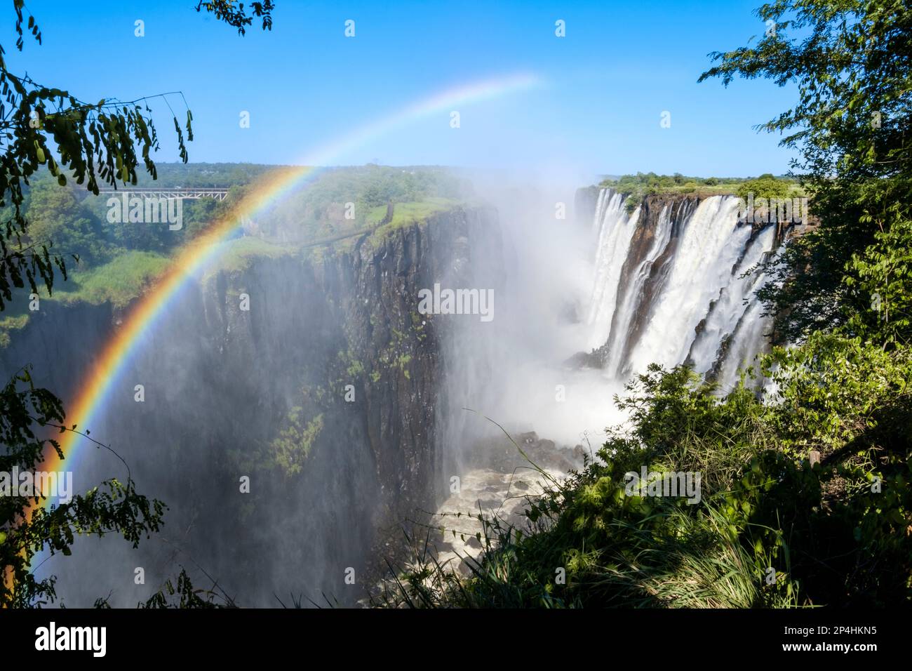 Waterfalls with rainbow, water falling down deep into the gorge. Victoria Waterfalls, Zambia, Africa Stock Photo