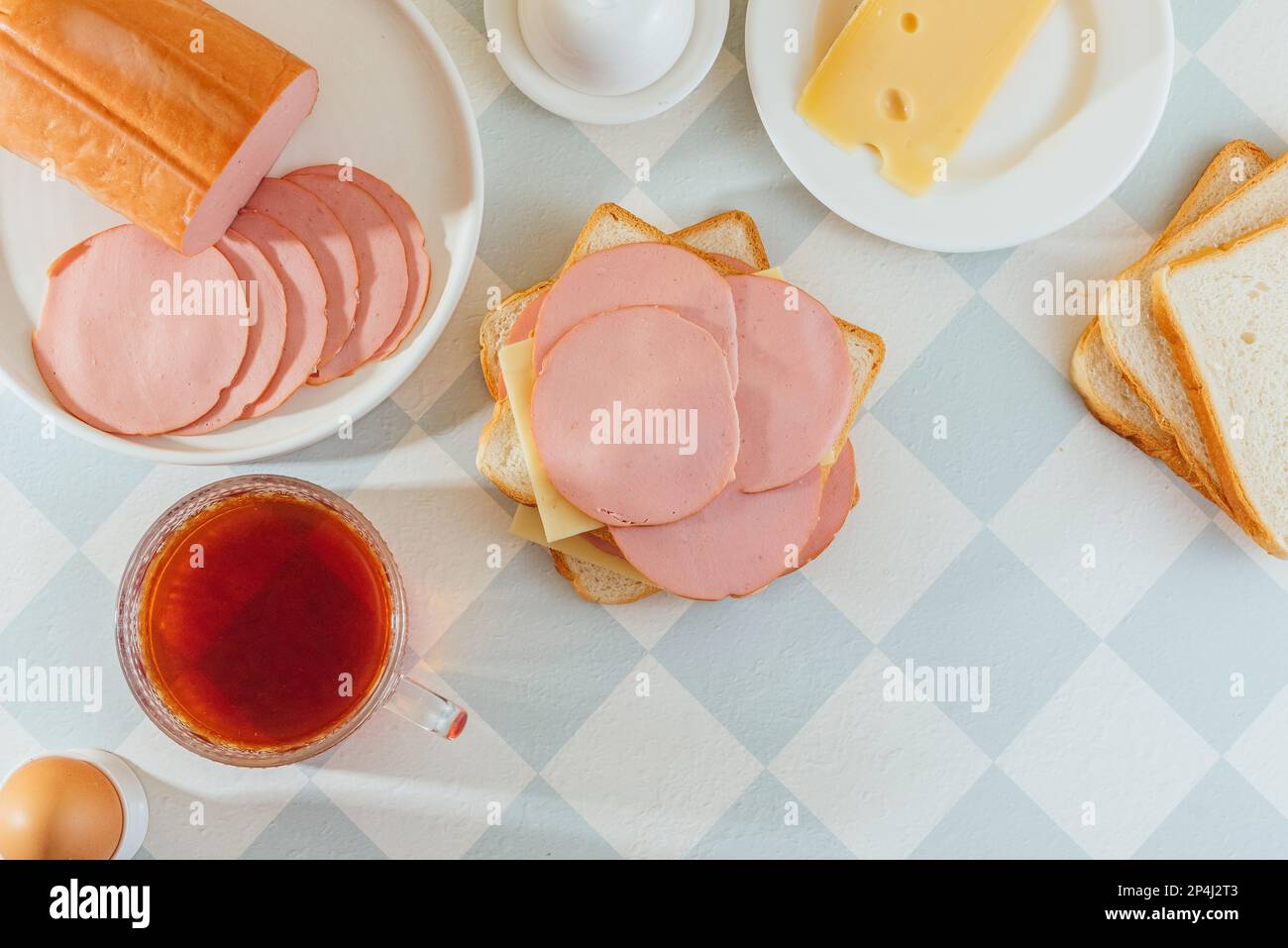 ham and cheese sandwich on a plate. ham is nearby. breakfast. Stock Photo